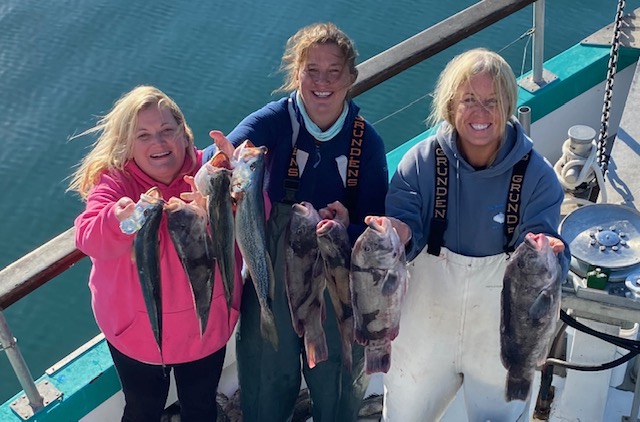 a group of people posing for a fish