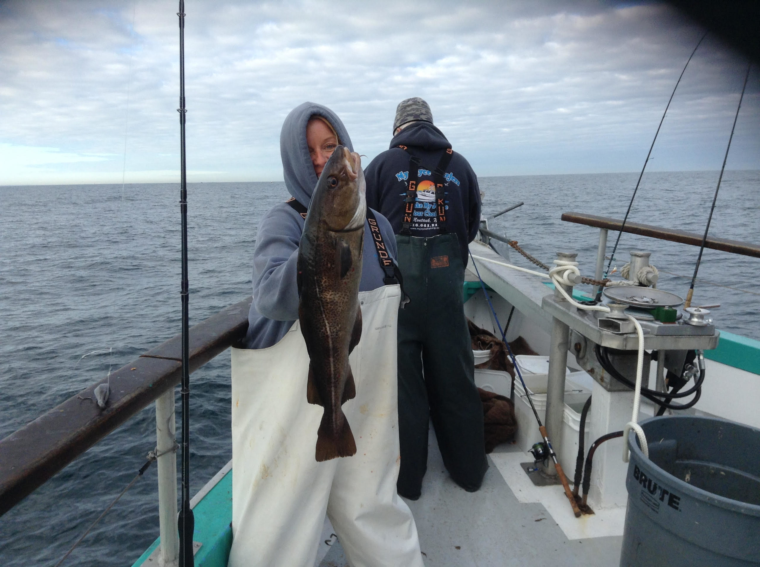 a person holding a fish on a boat in a body of water