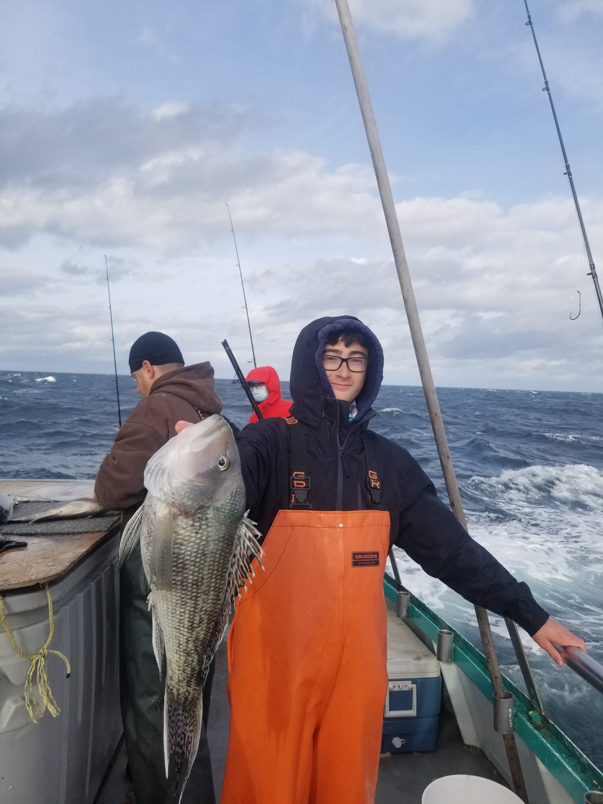 a man holding a fish on a boat