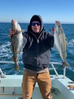 a man holding a fish on a boat in the water
