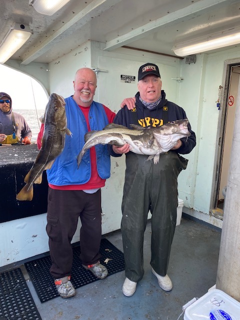 a man holding a fish posing for the camera