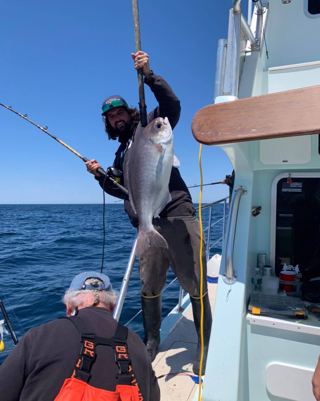 a man holding a fish on a boat