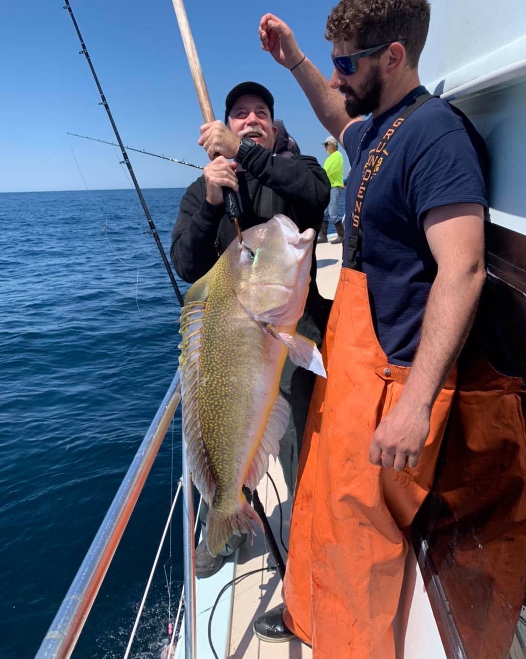 a man holding a fish on a boat