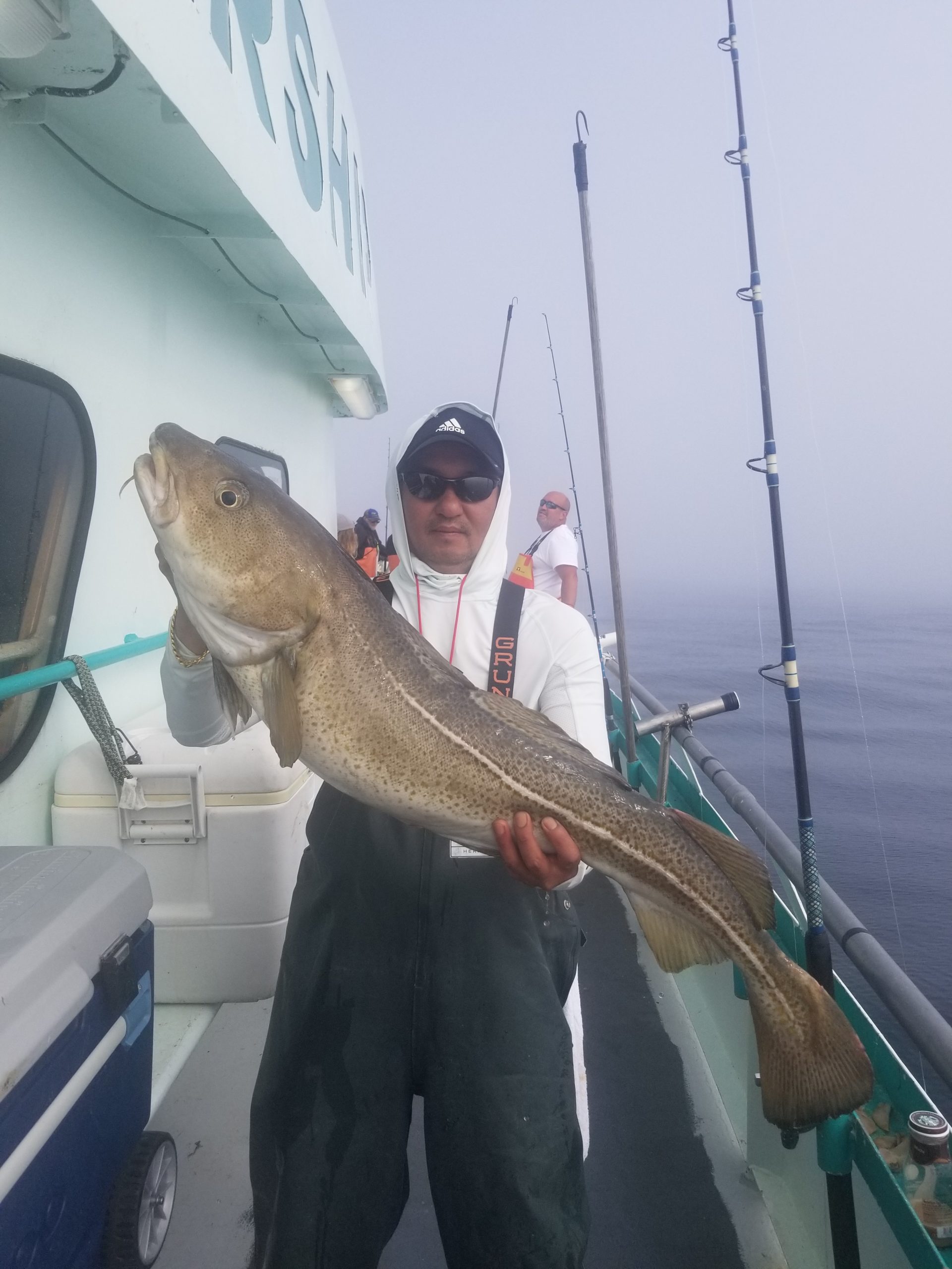 a man holding a fish on a boat