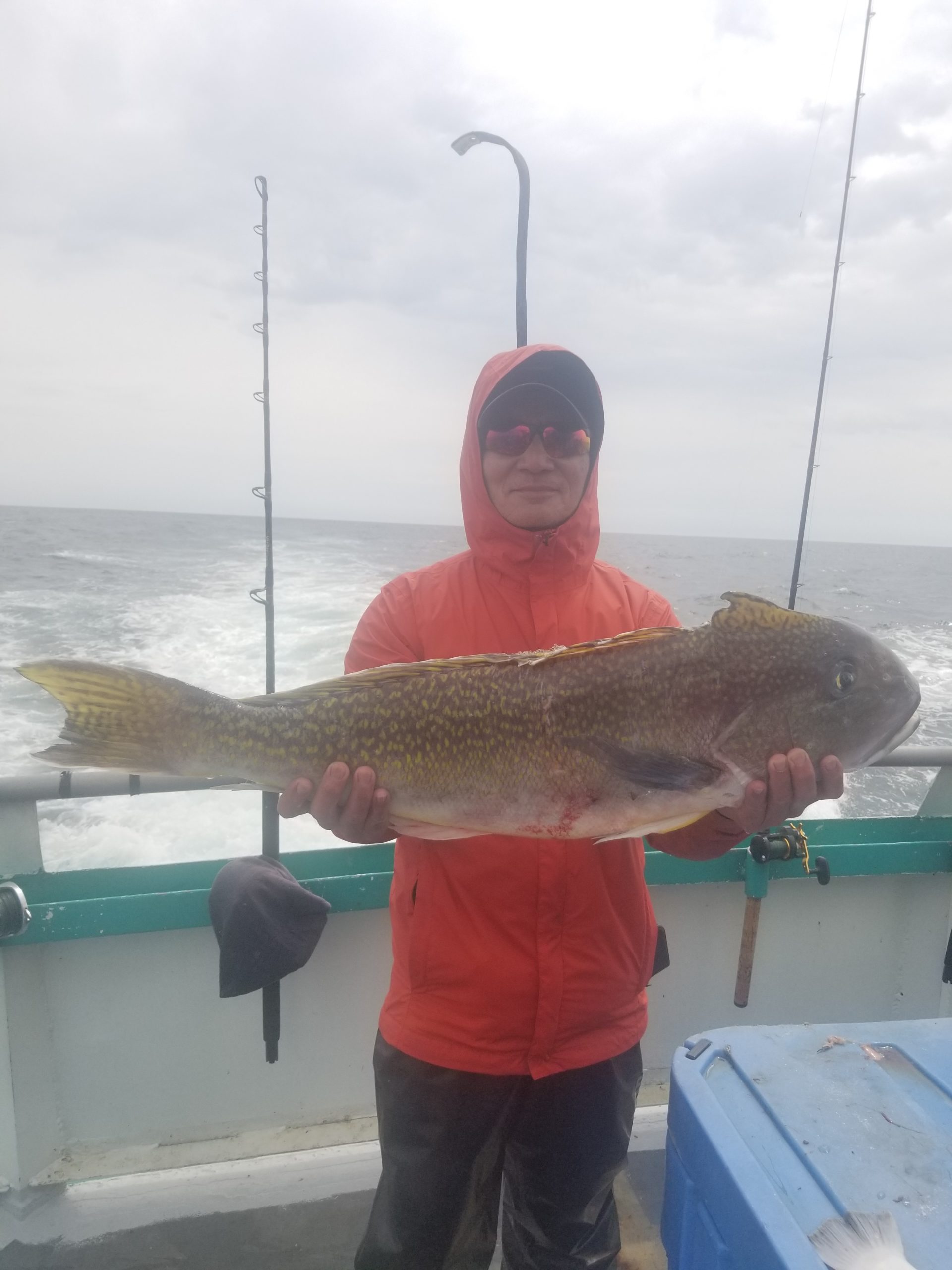a man holding a fish on a boat