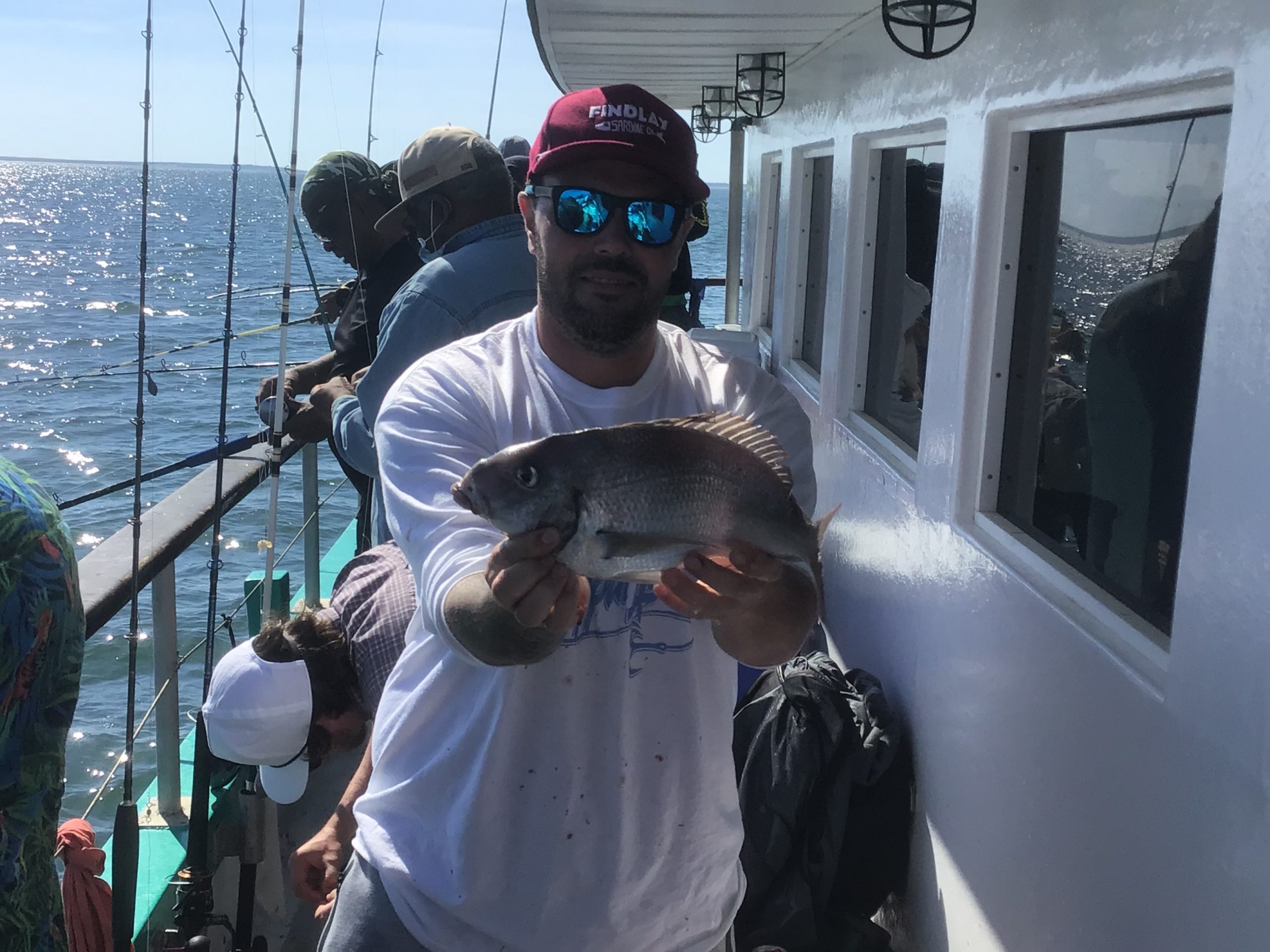 a man holding a fish on a boat
