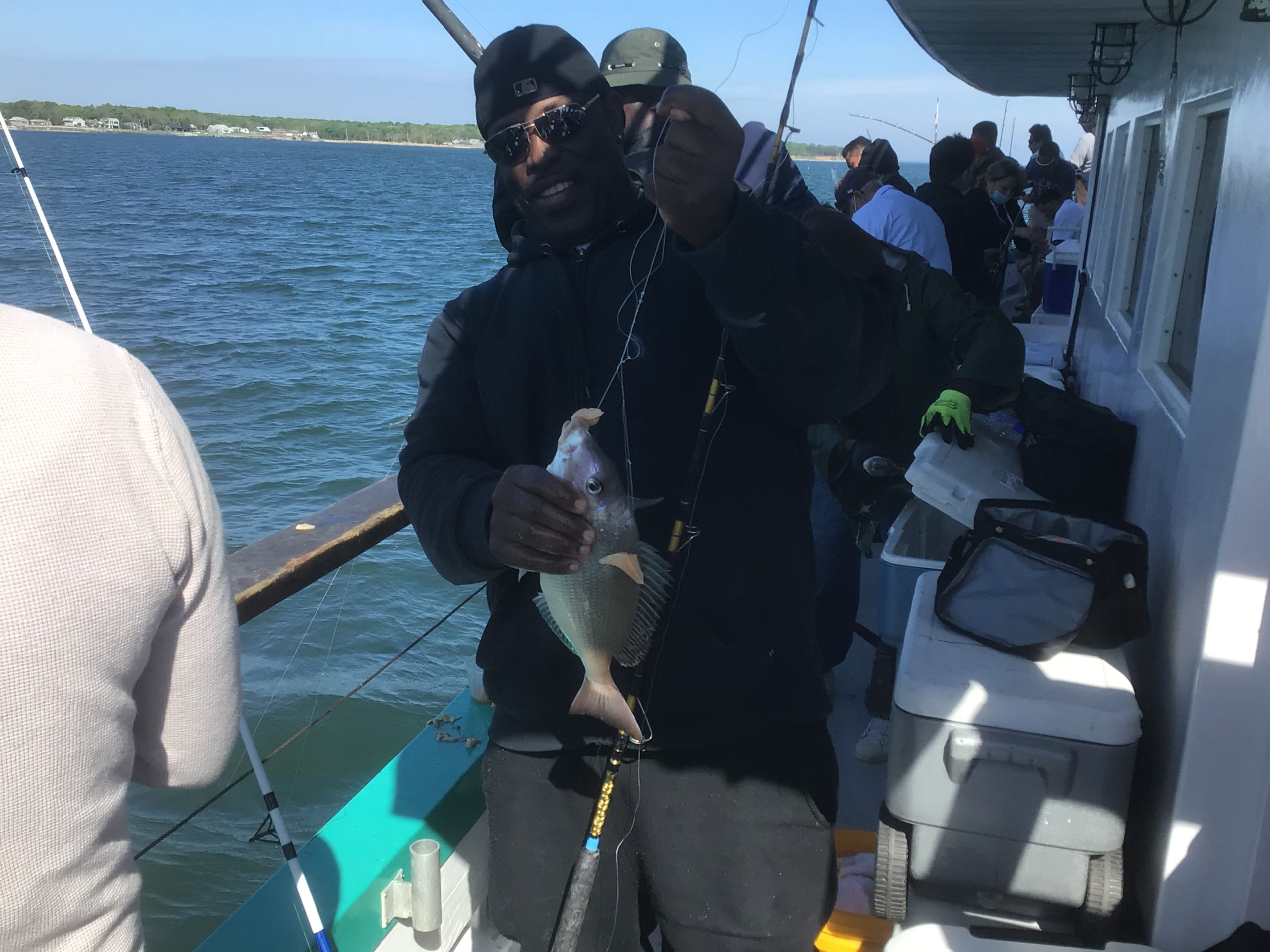 a man holding a fish on a boat in the water