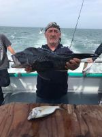 Edward Woodward holding a fish in the water