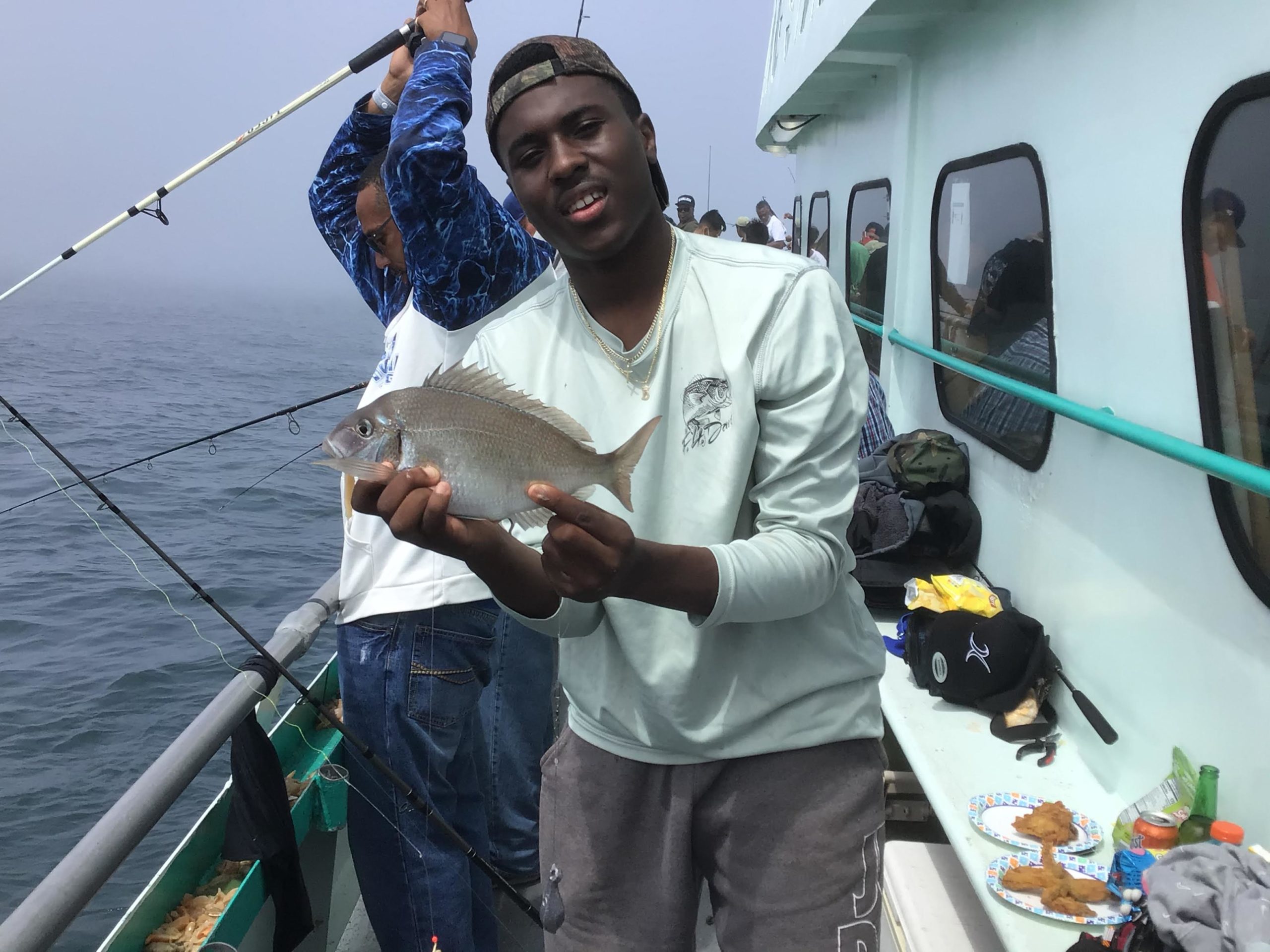 a person holding a fish on a boat
