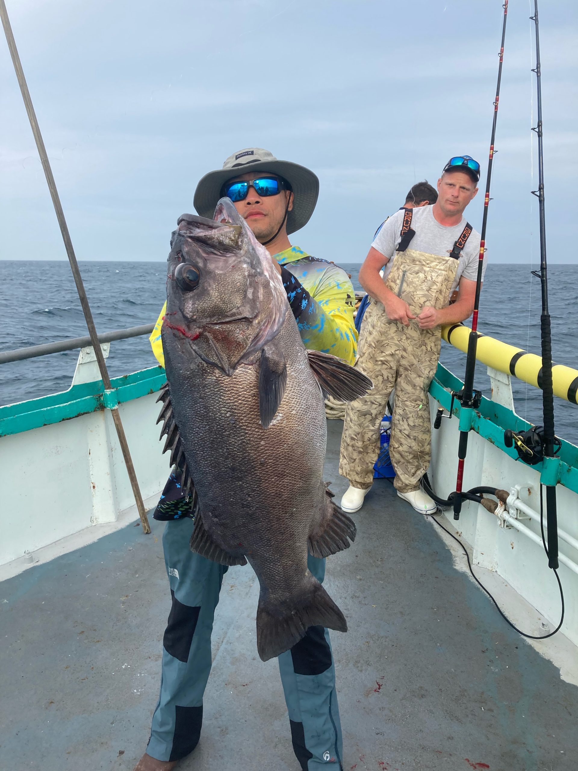 a man holding a fish on a boat