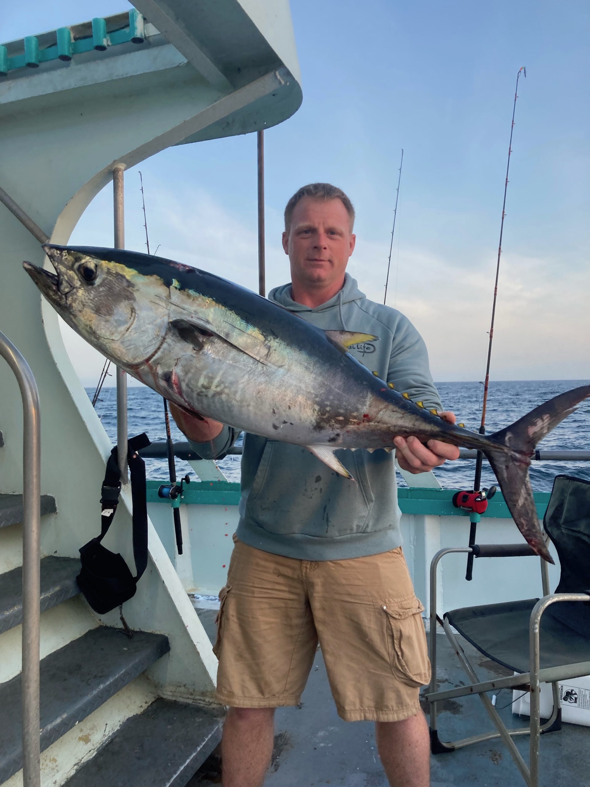 a man holding a fish on a boat
