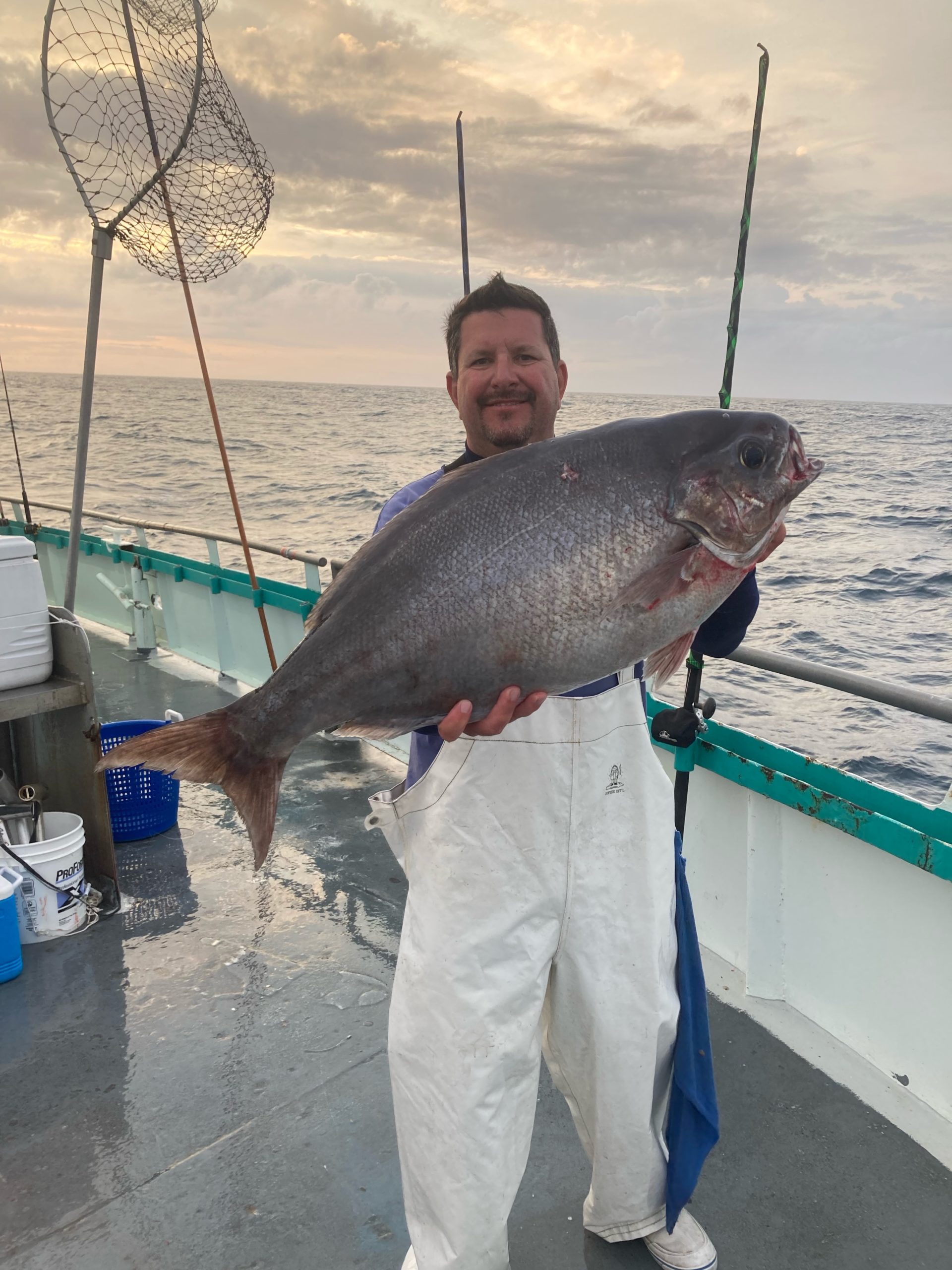 a man holding a fish in the water