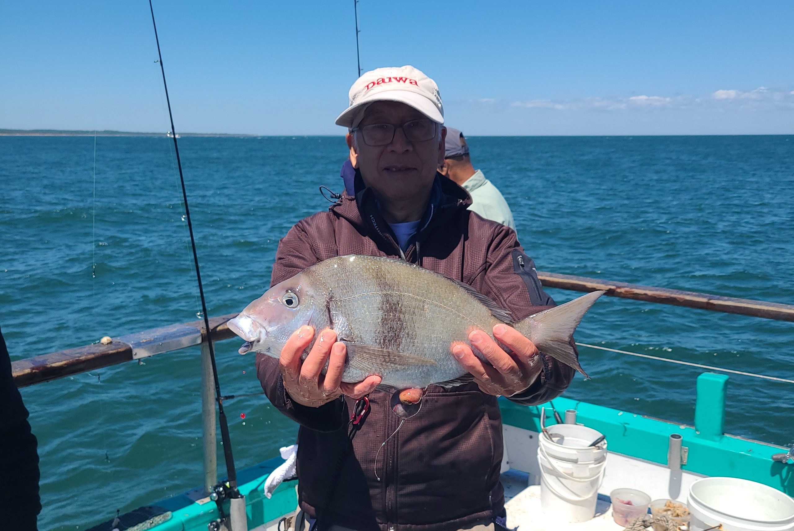 a person holding a fish on a boat in a body of water