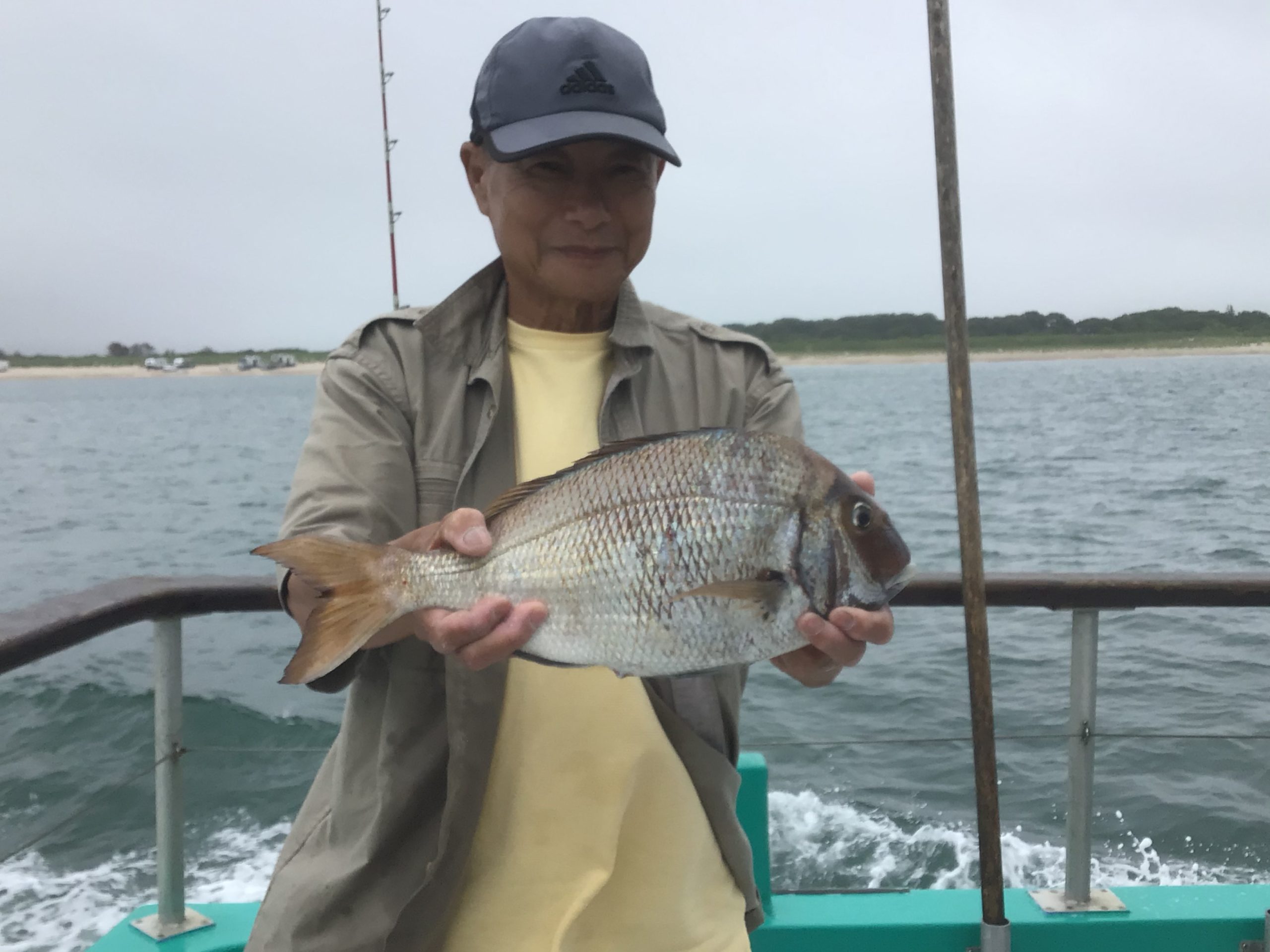 a person holding a fish on a boat in a body of water