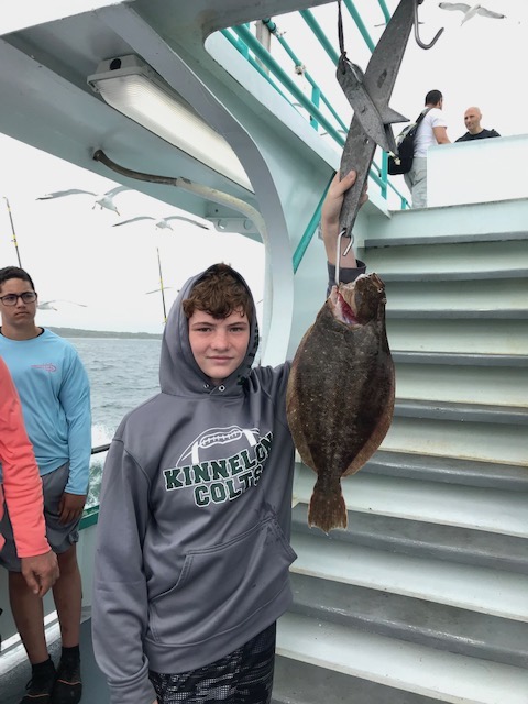 a group of people standing in front of a fish
