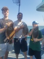 a group of people standing next to a person holding a fish