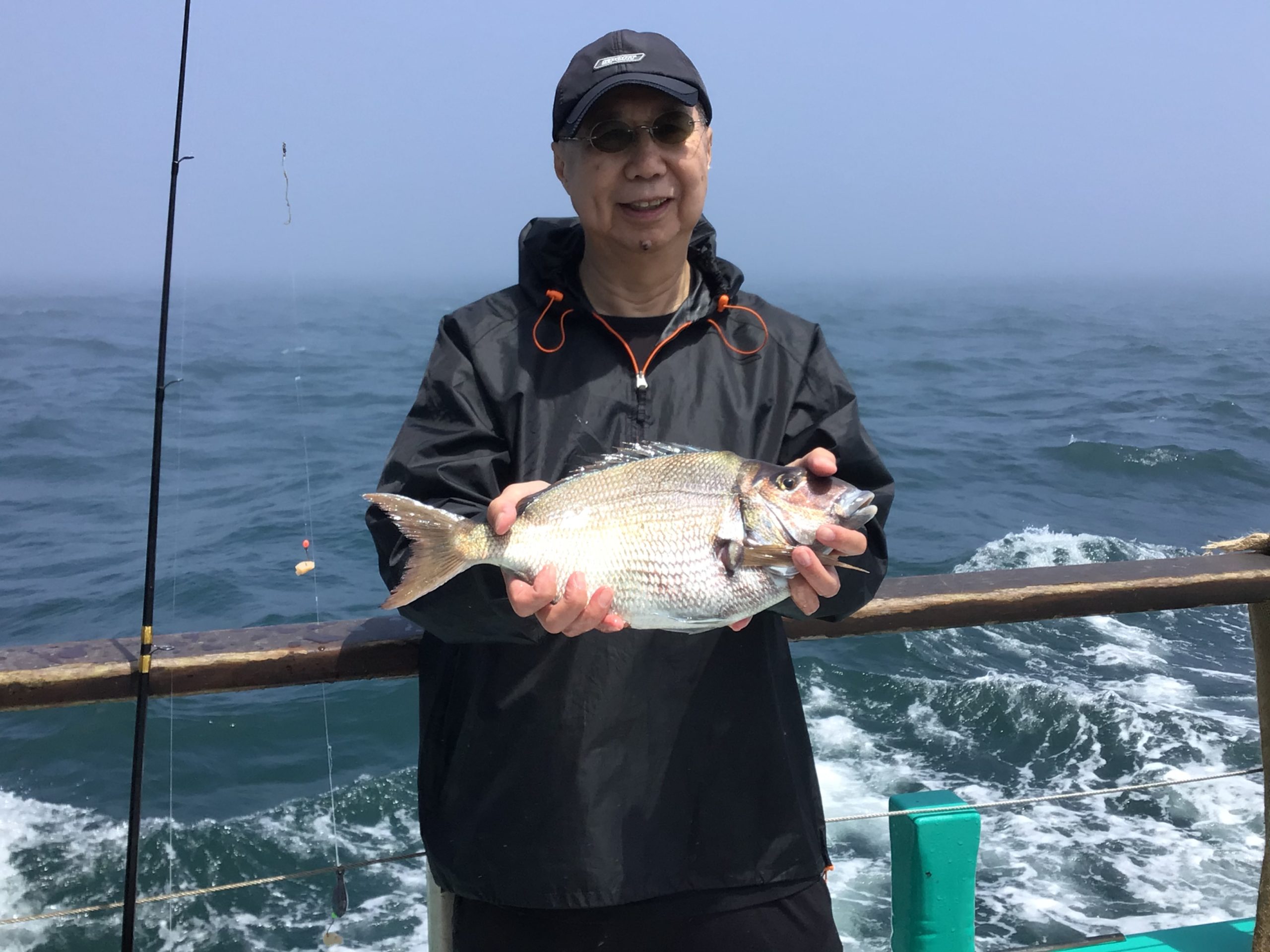 a person holding a fish on a boat in a body of water