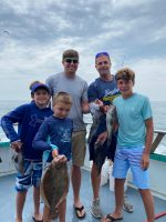 Jake Goodman et al. standing next to a person holding a fish