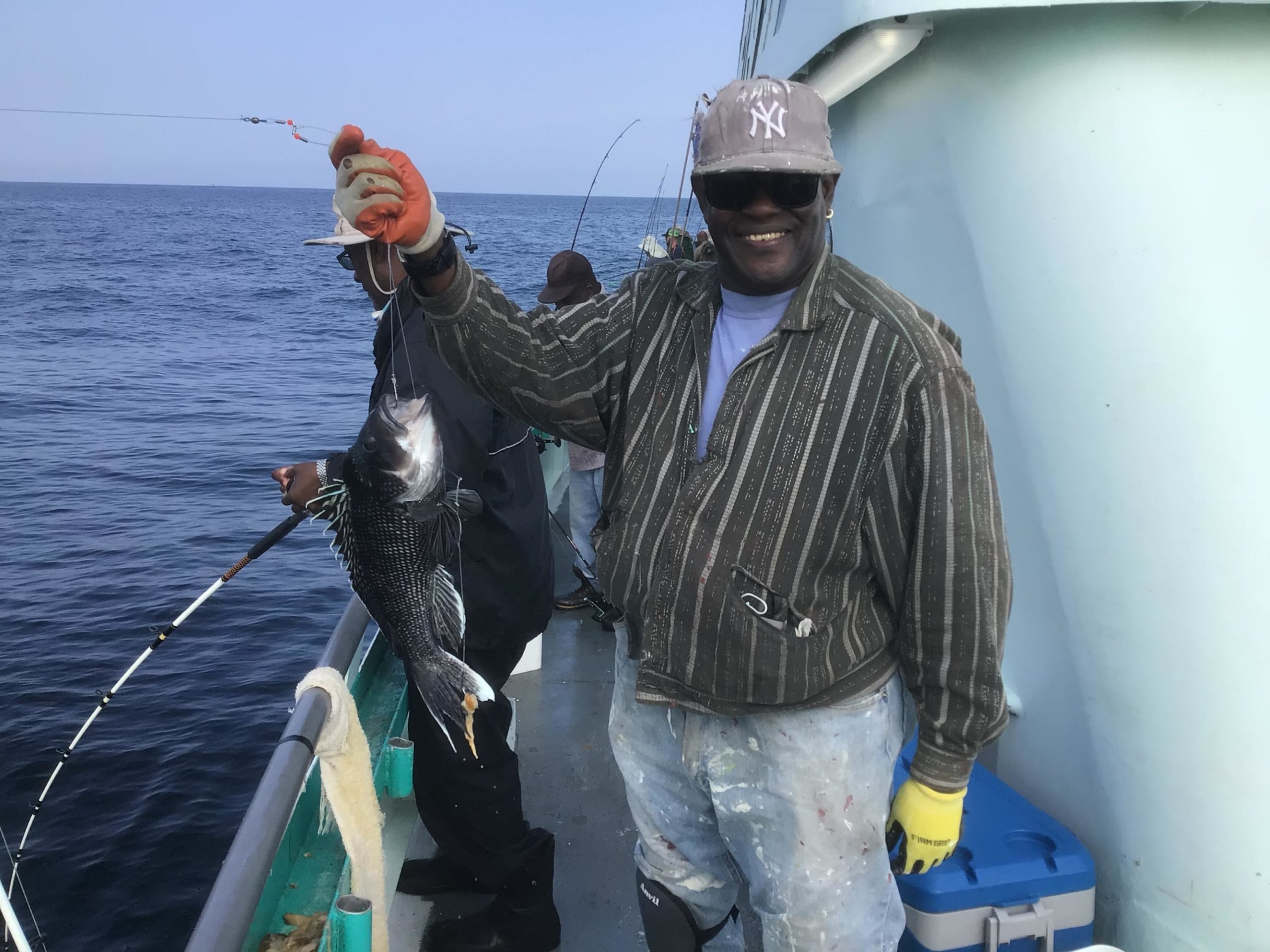 a man holding a fish on a boat in the water