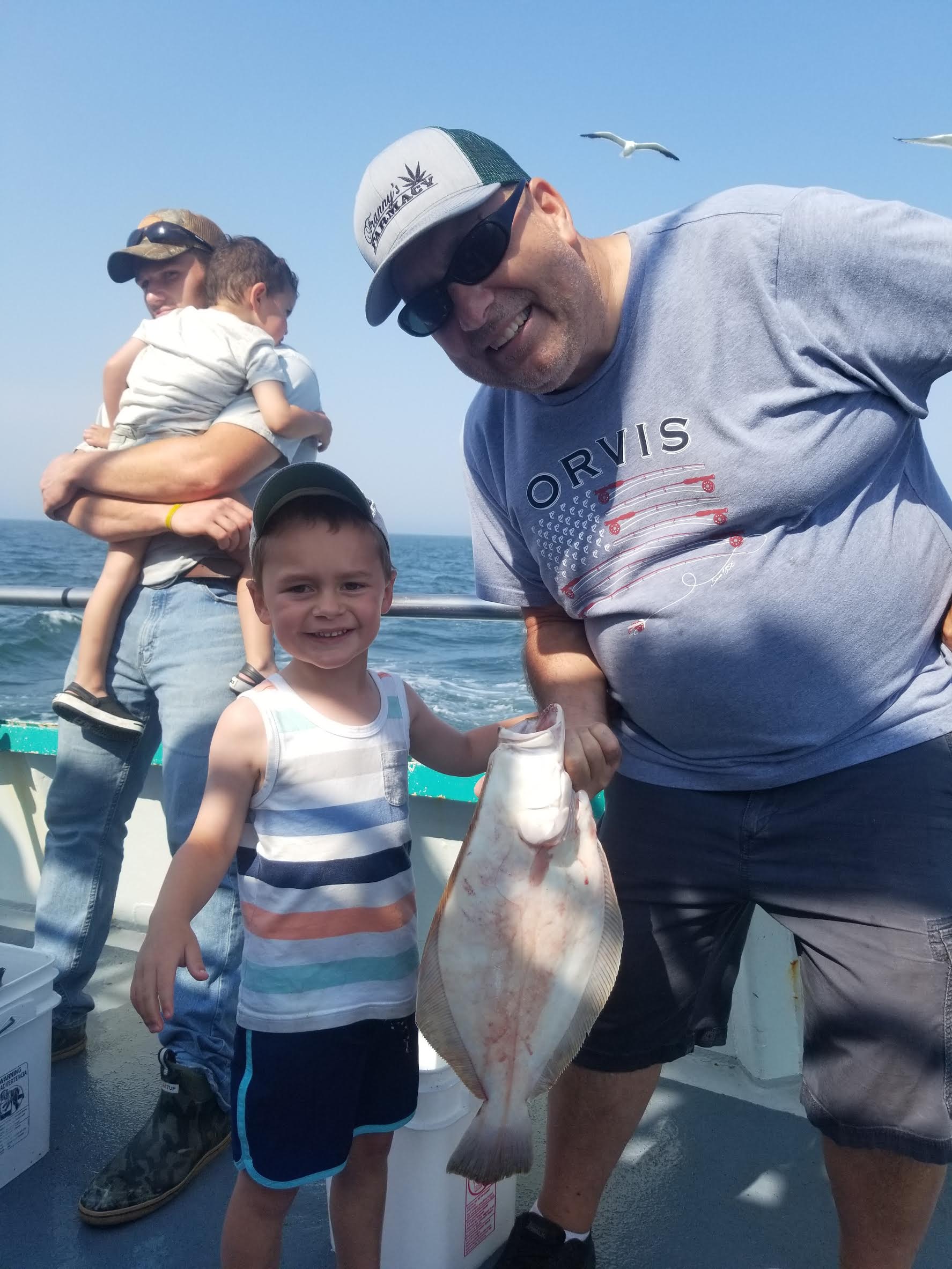 a group of people standing next to a person holding a fish