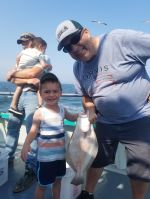 a group of people standing next to a person holding a fish