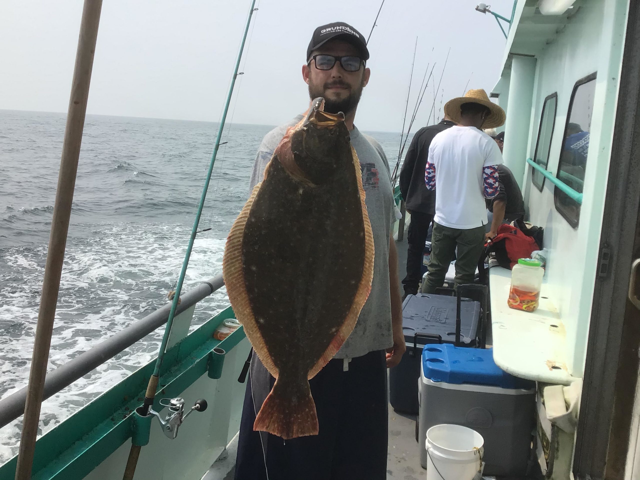 a man holding a fish on a boat