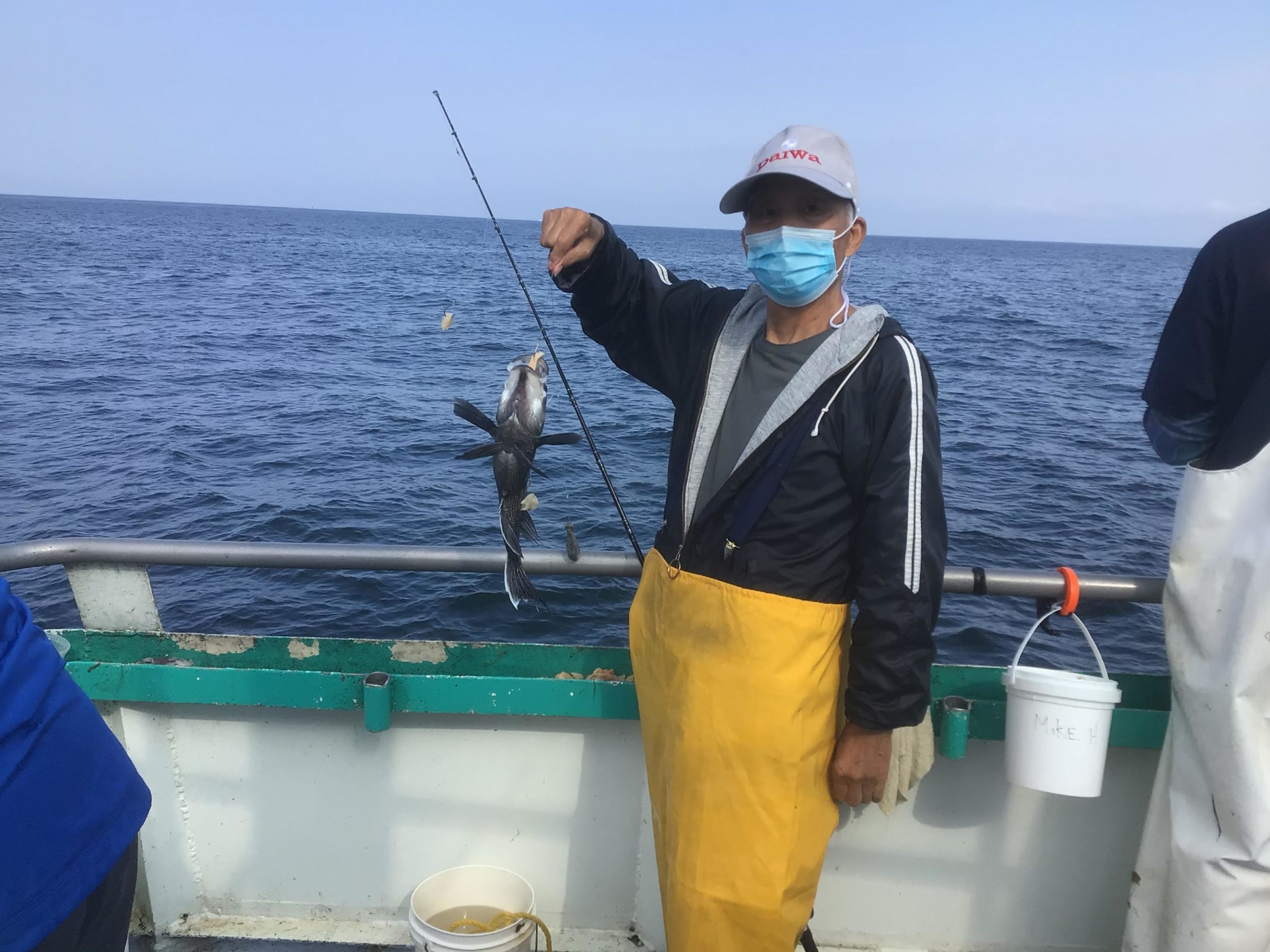 a person holding a fish on a boat in the water
