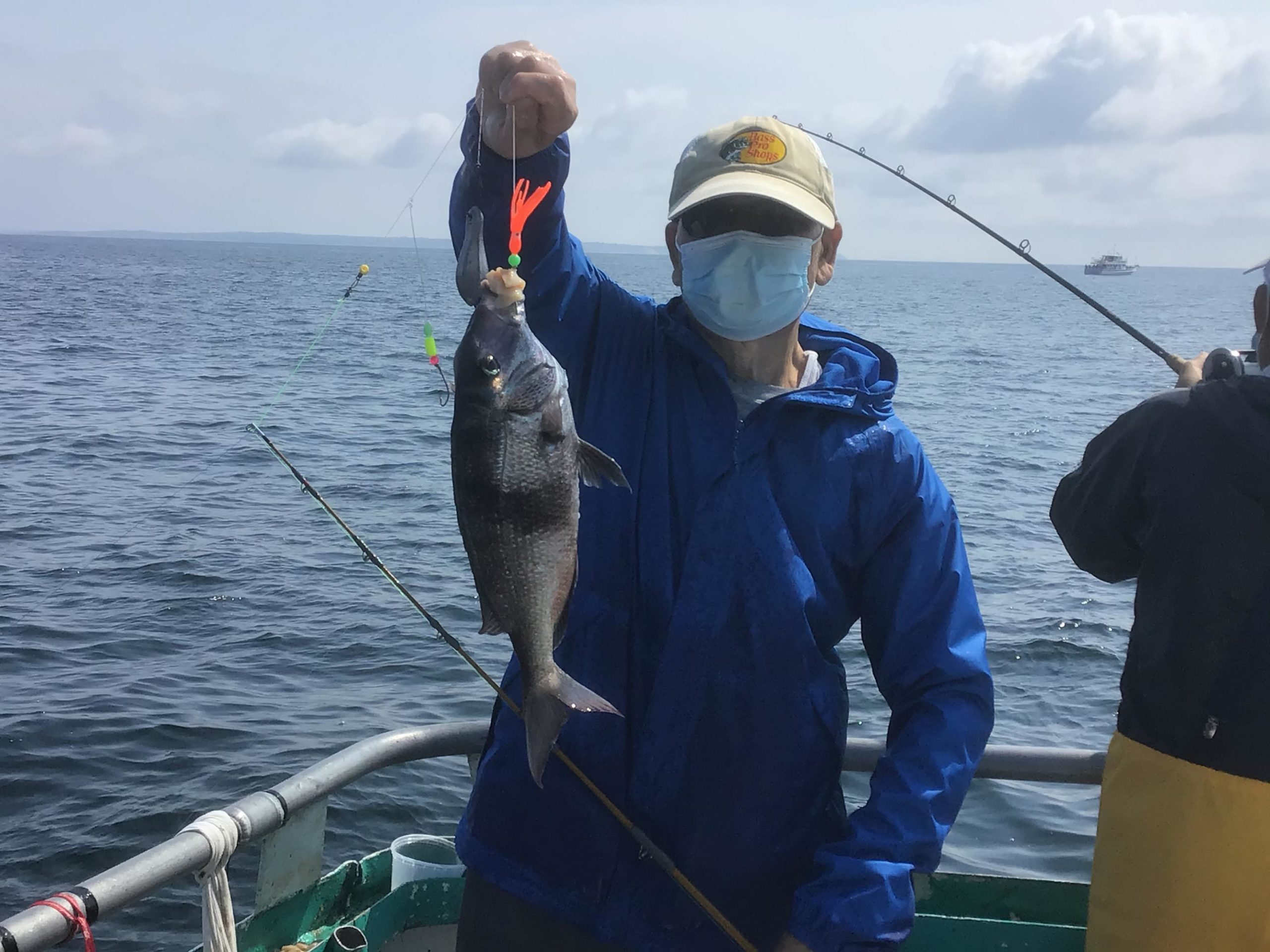 a man holding a fish on a boat in a body of water