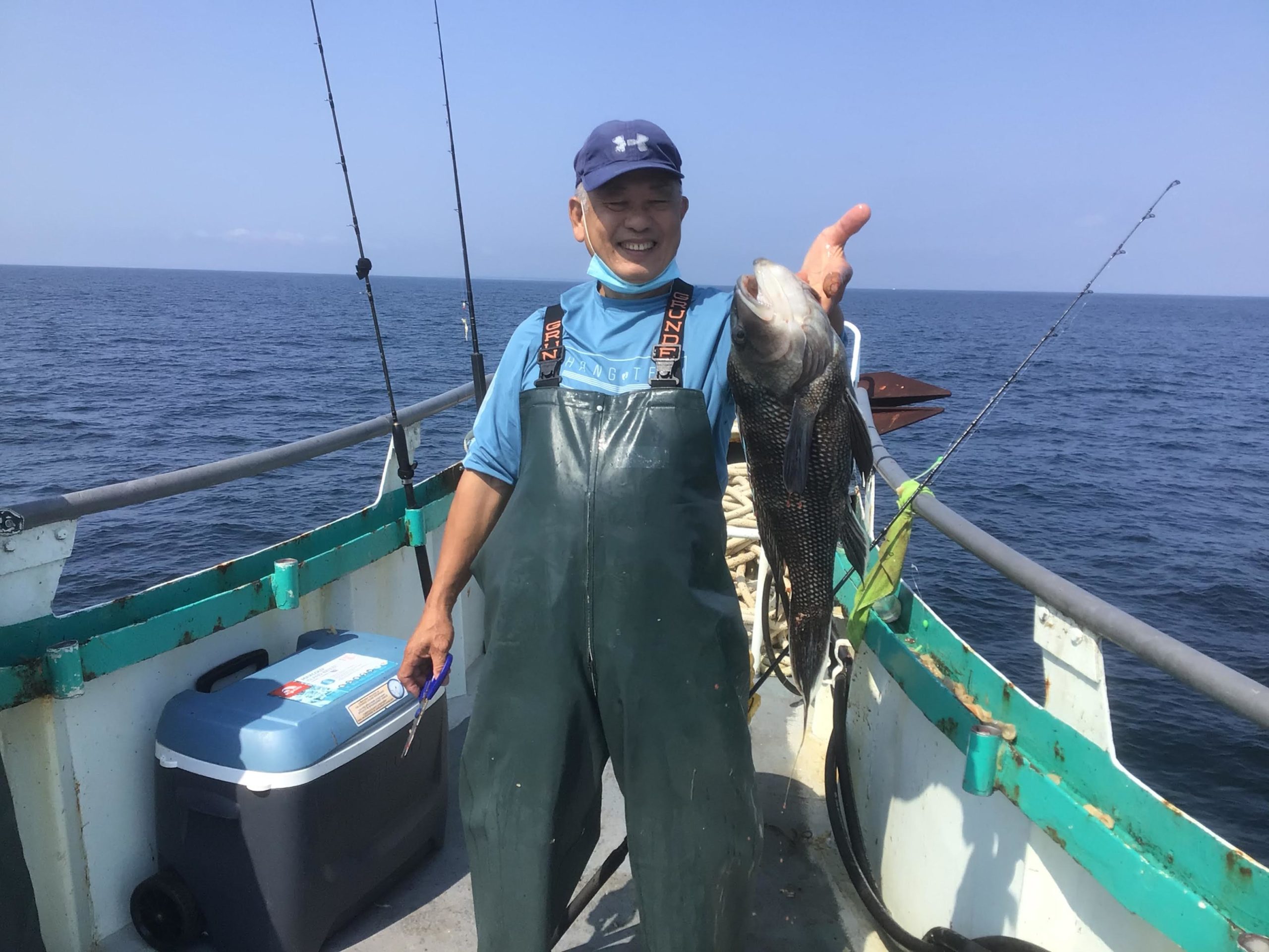 a person holding a fish on a boat in the water