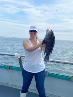 a woman standing next to a body of water