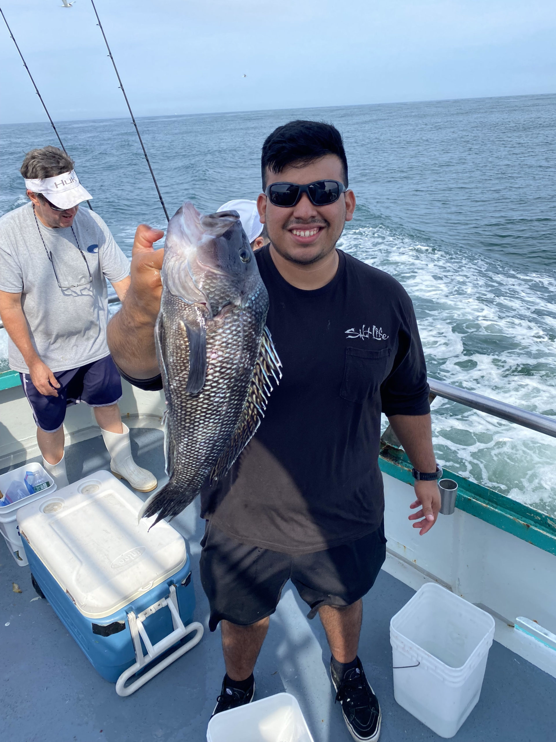 a man holding a fish on a boat