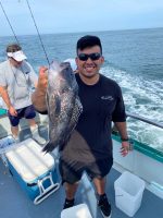 a man holding a fish on a boat