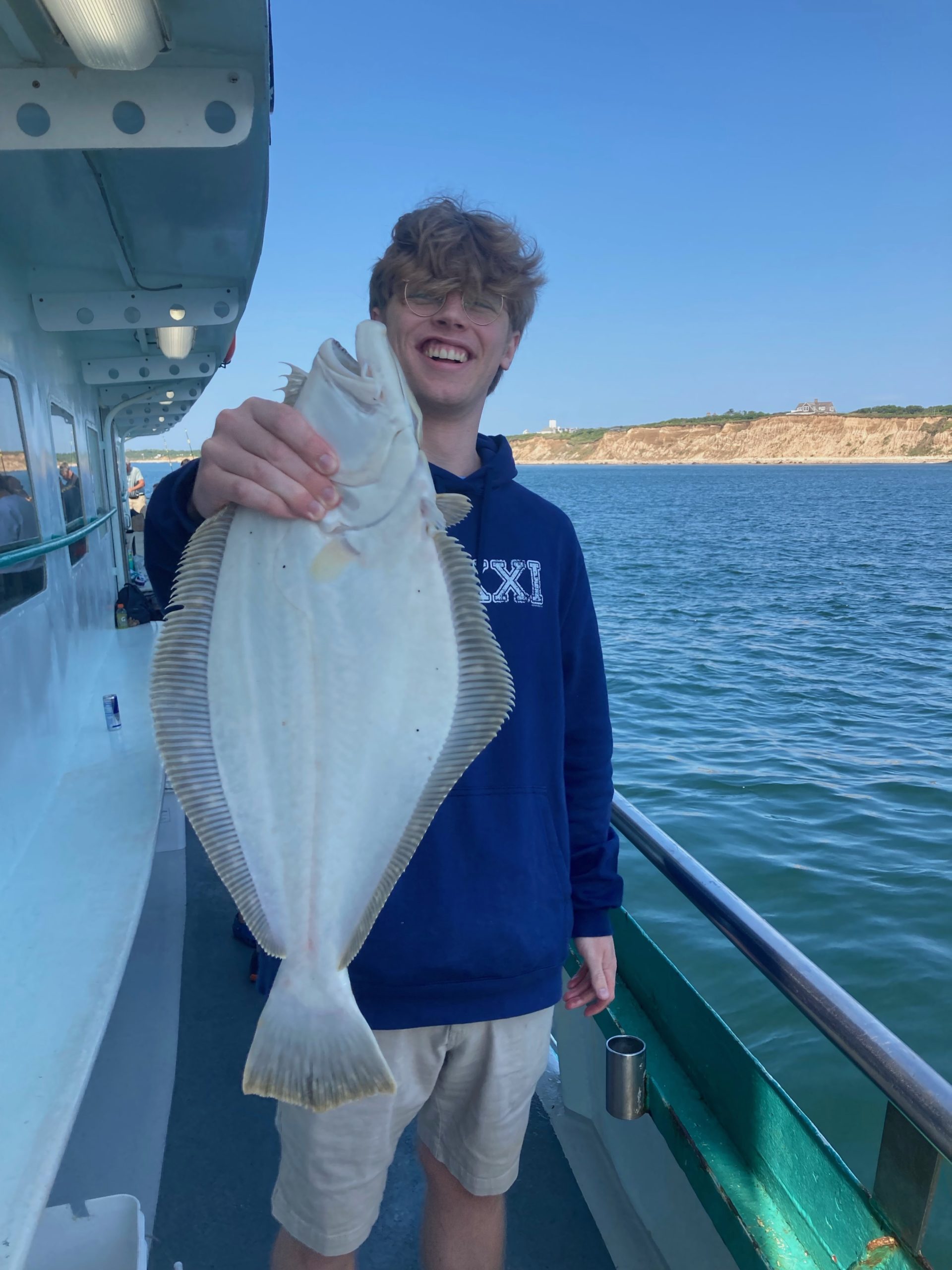 a man holding a fish on a boat posing for the camera