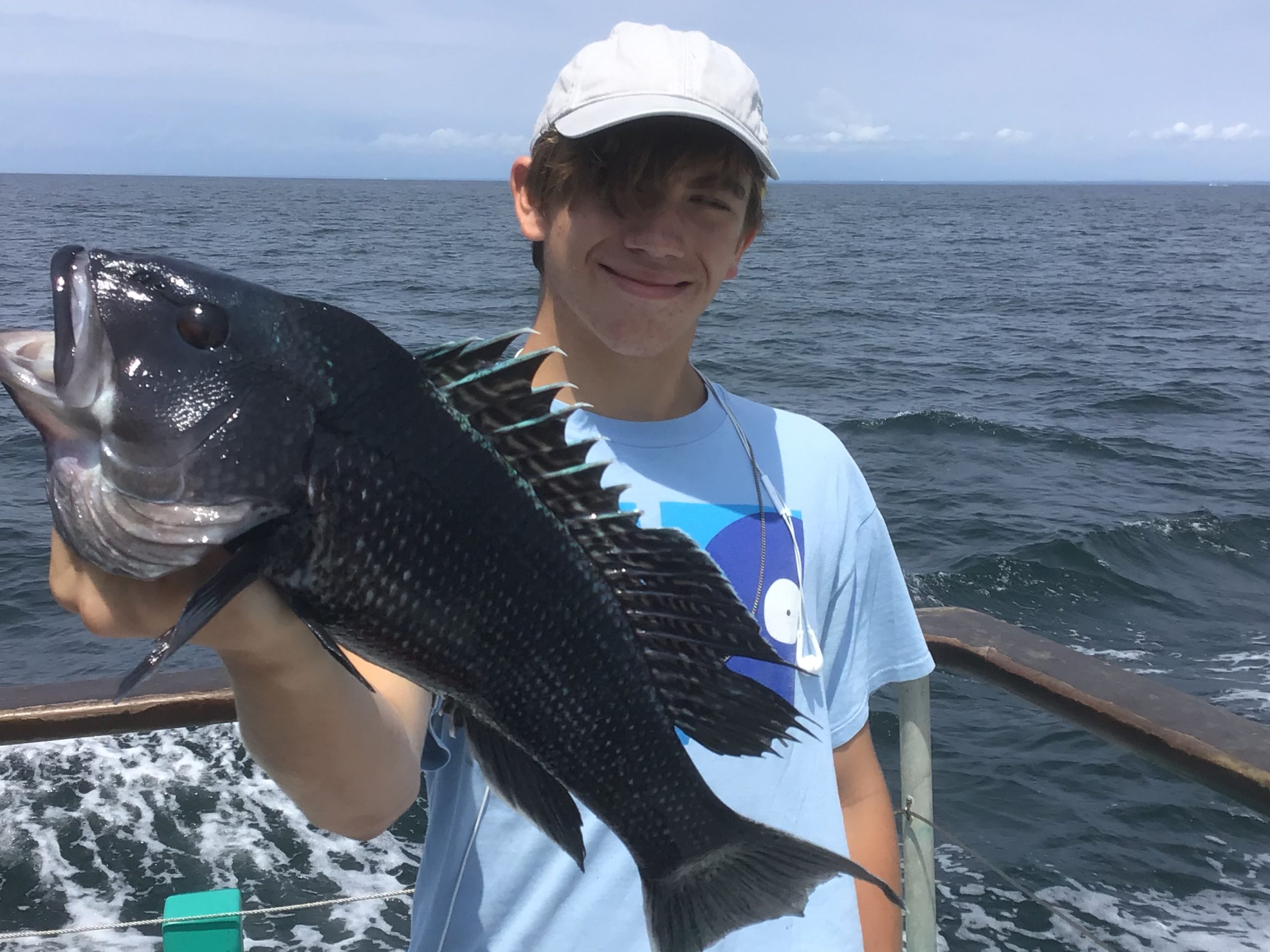 a person holding a fish on a boat in a body of water