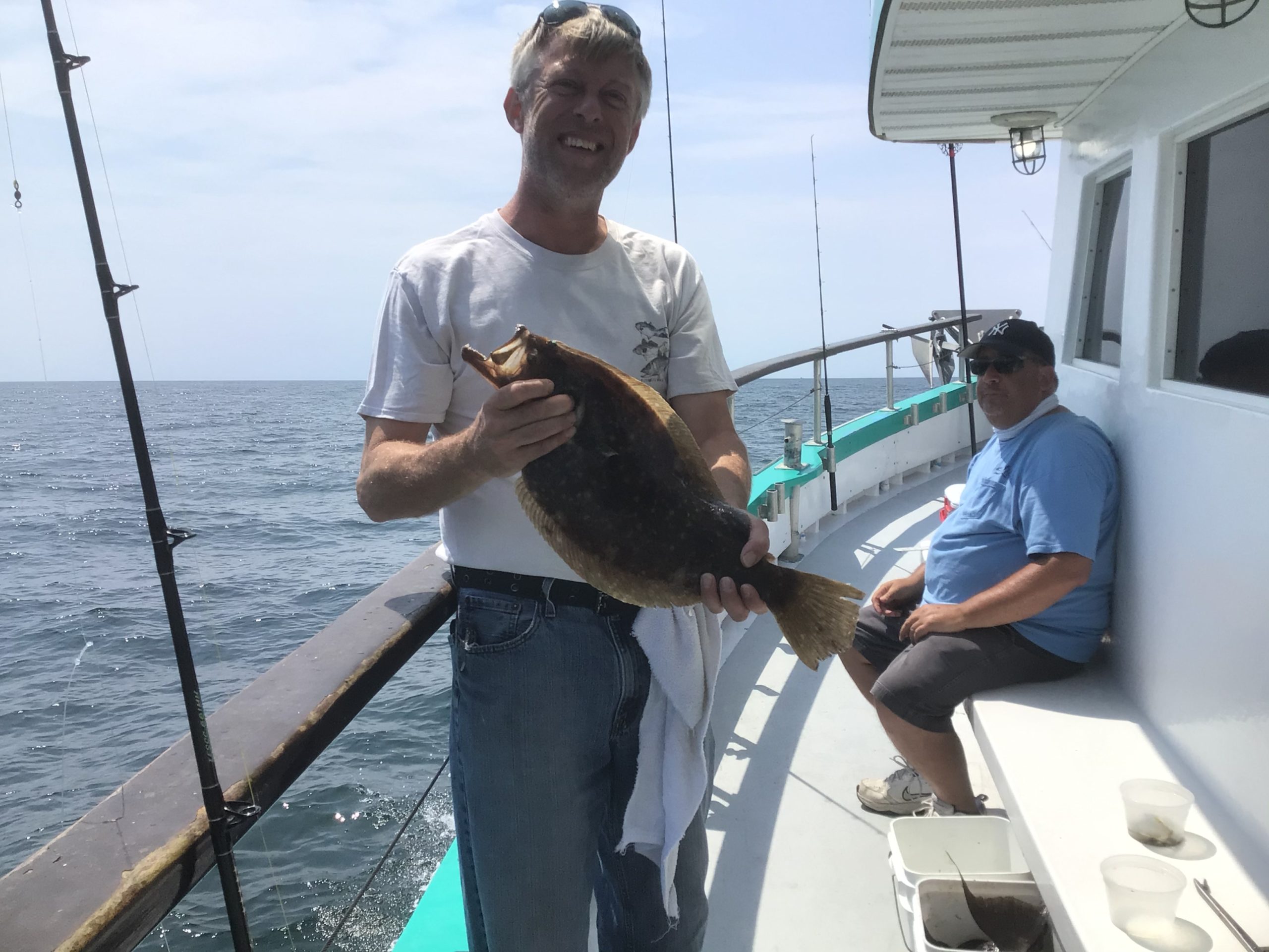 a man holding a fish on a boat
