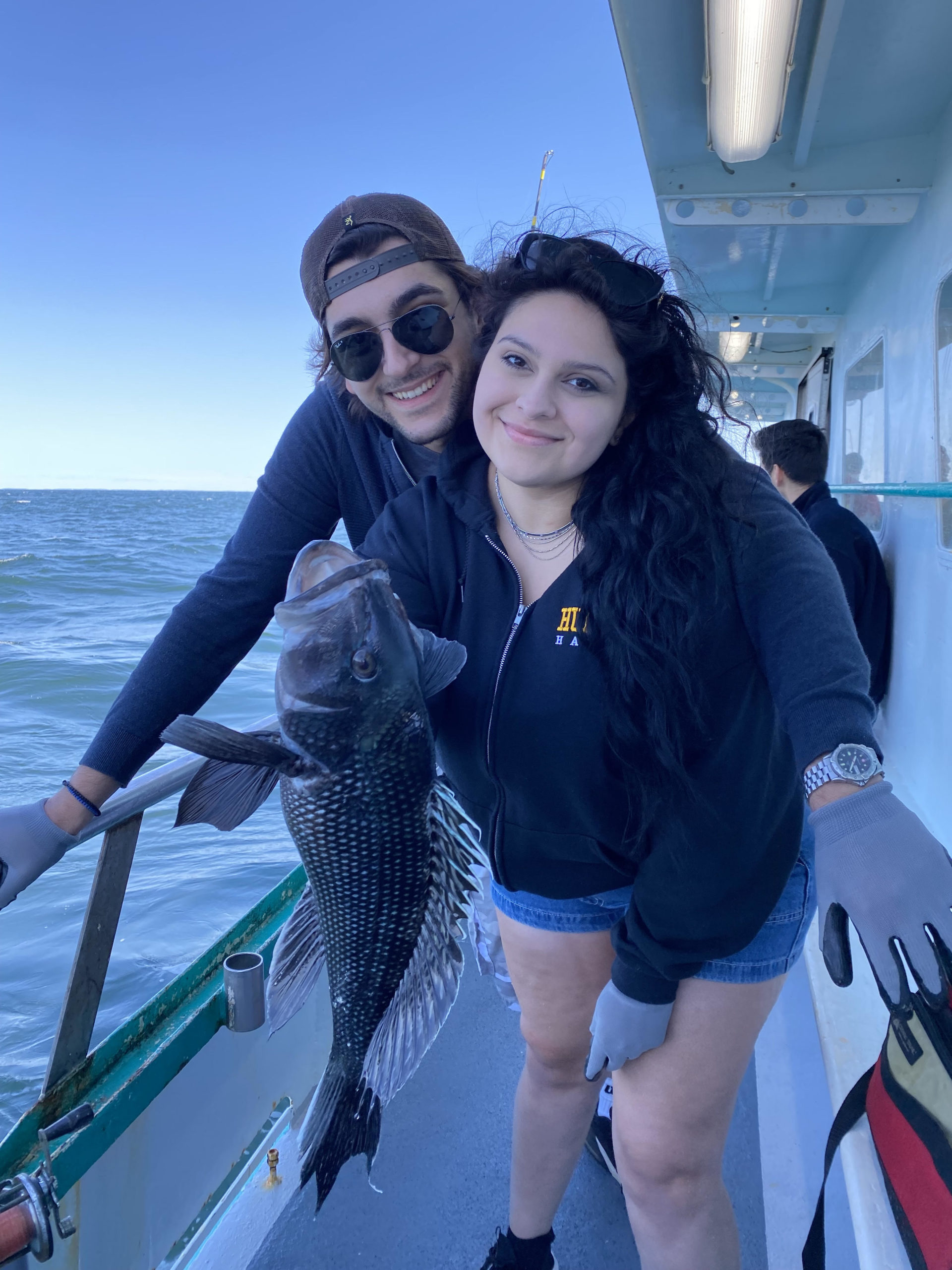 a person holding a fish on a boat posing for the camera