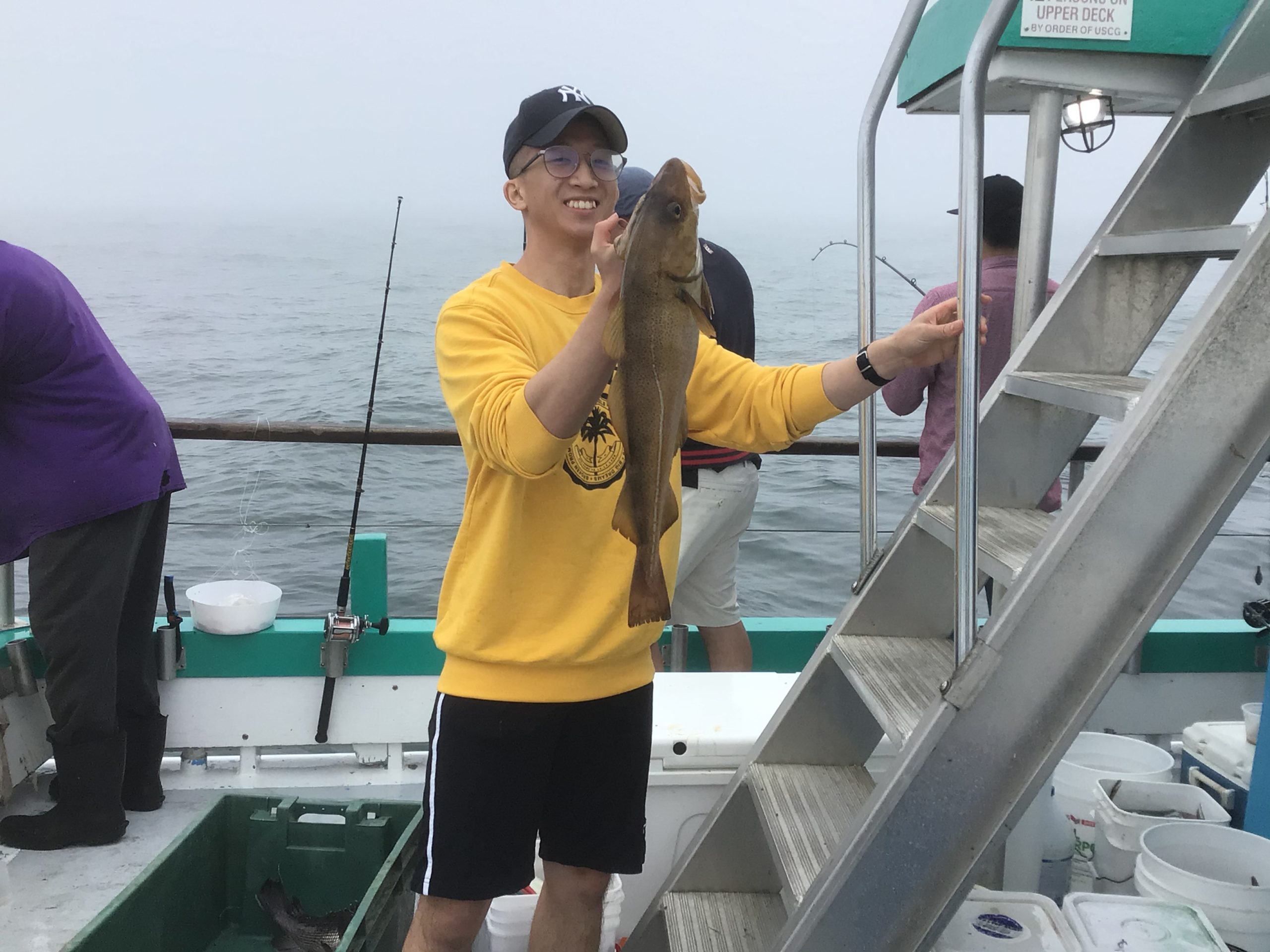 a man holding a fish on a boat
