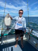 a person holding a fish on a boat in the water