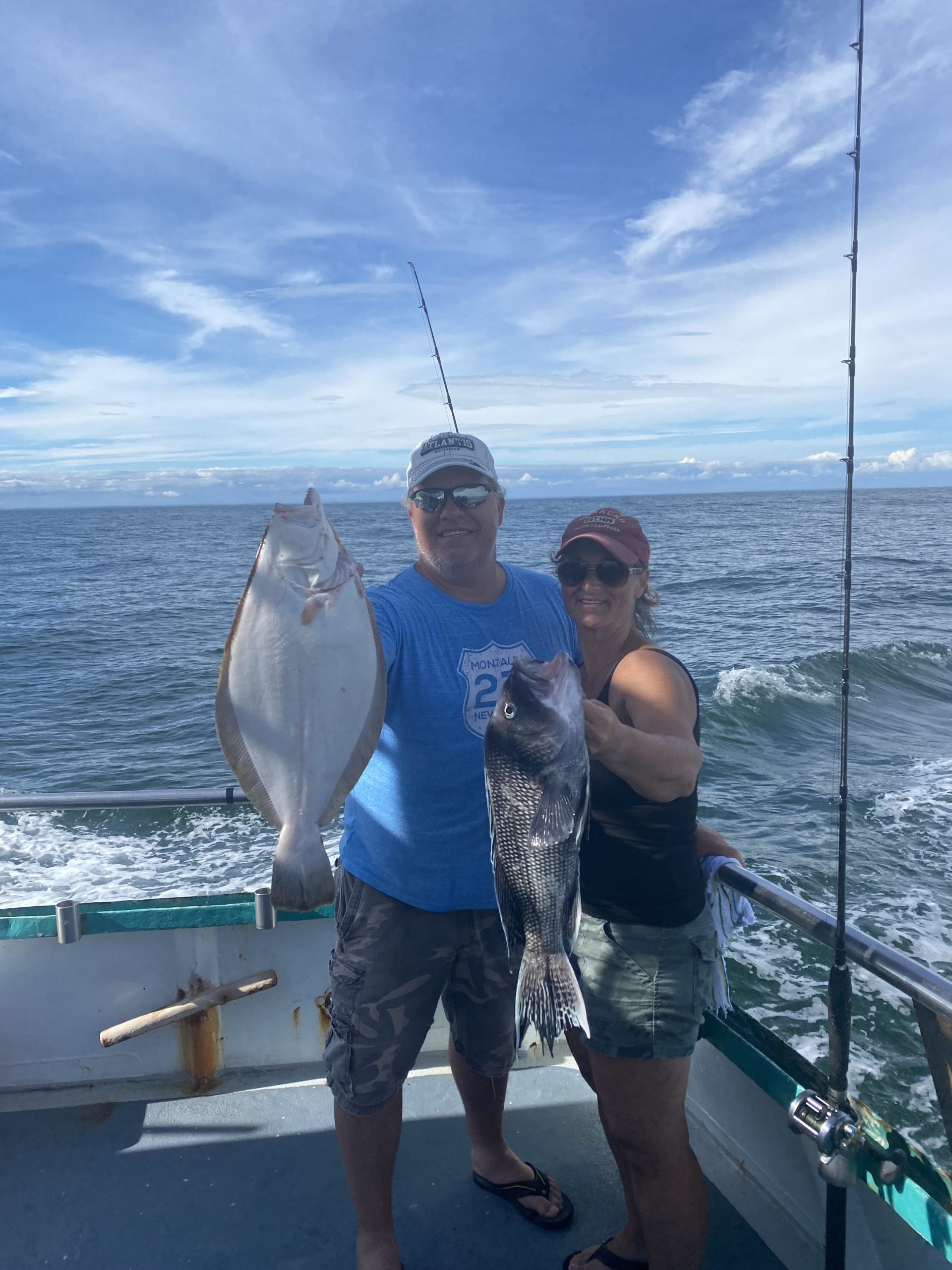 a man holding a fish on a boat in the water
