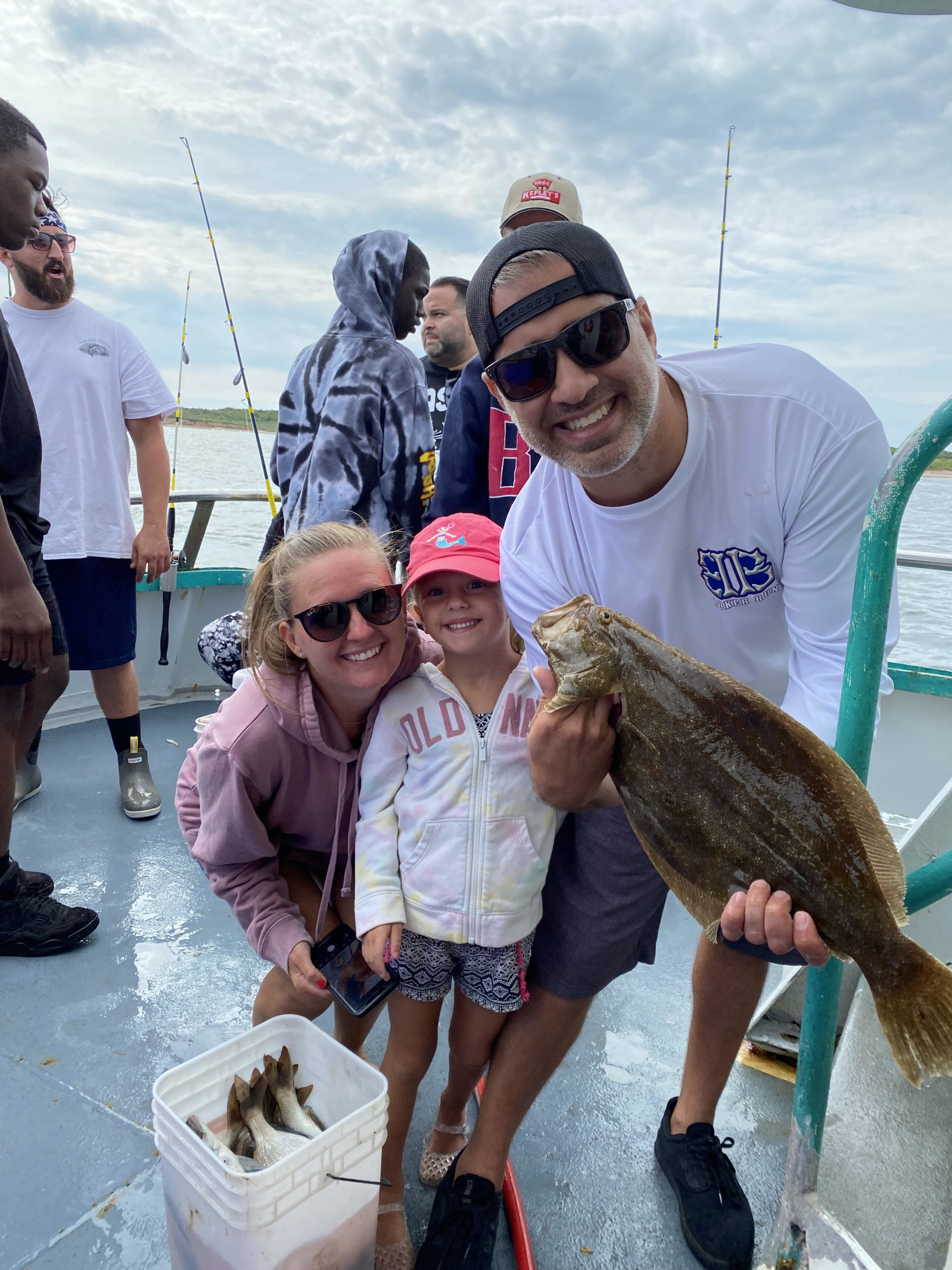 a group of people standing next to a person holding a fish