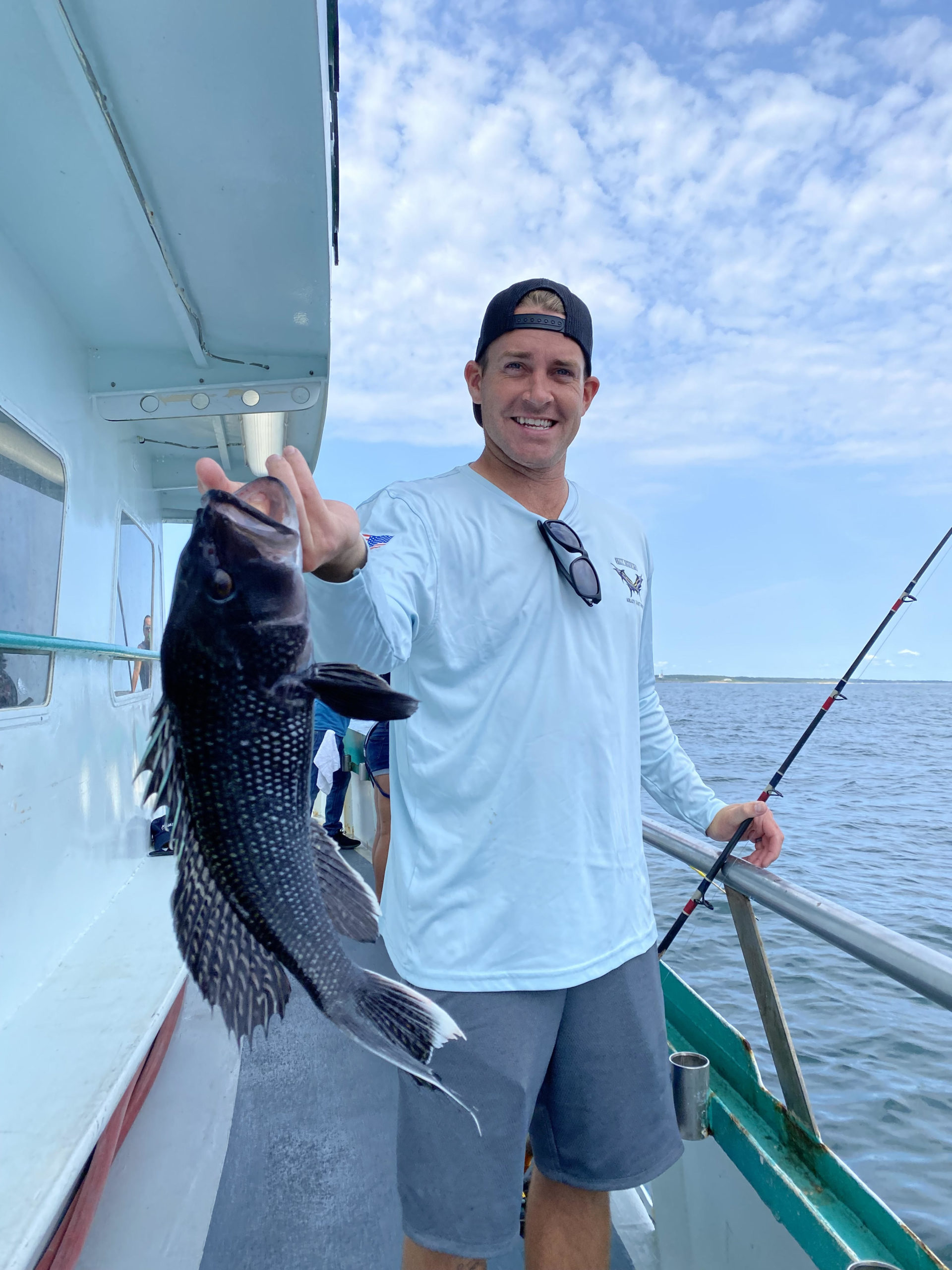 a man holding a fish on a boat