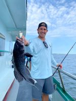 a man holding a fish on a boat