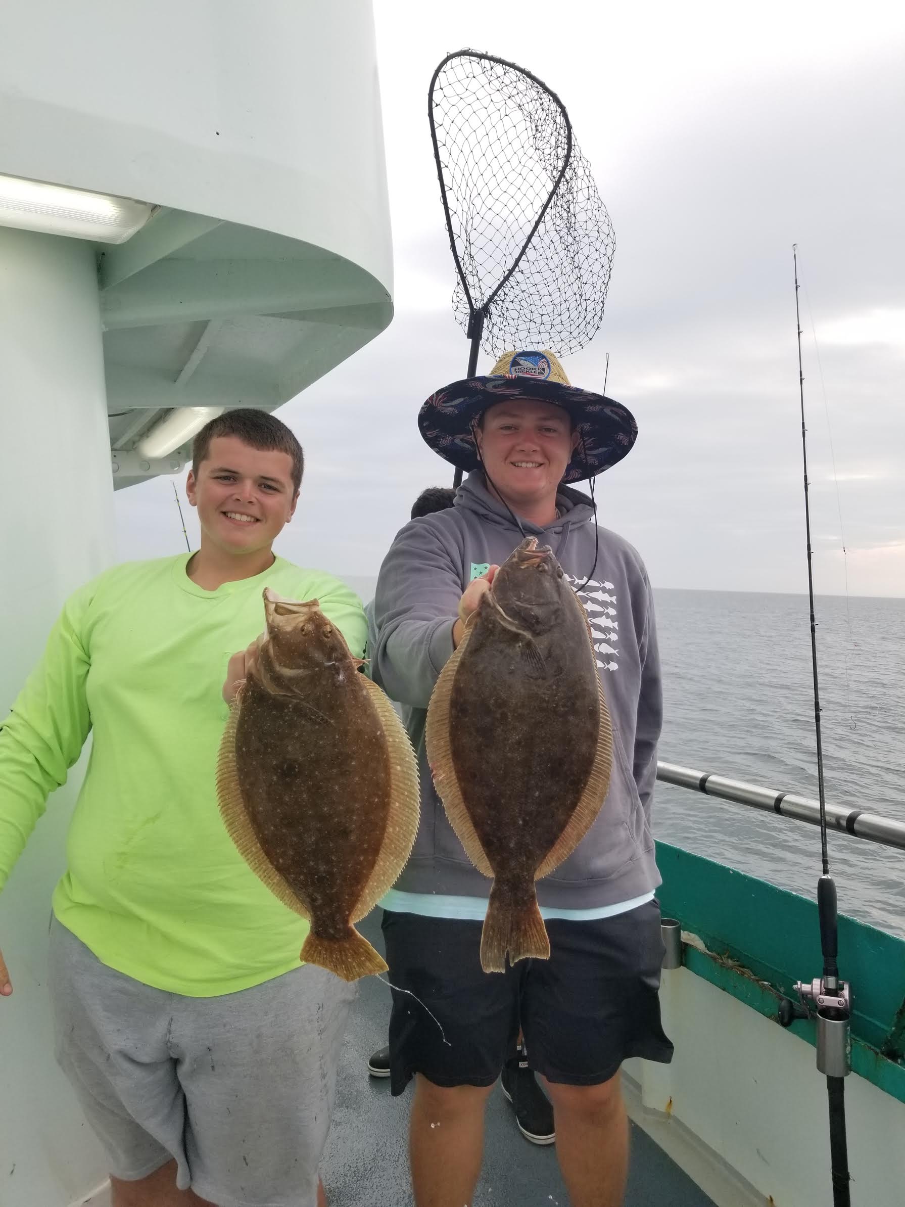a person holding a fish on a boat posing for the camera