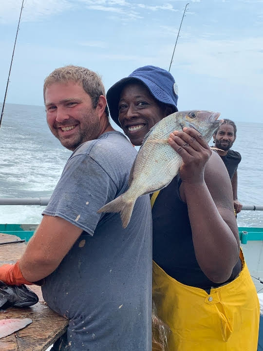 a person holding a fish in the water