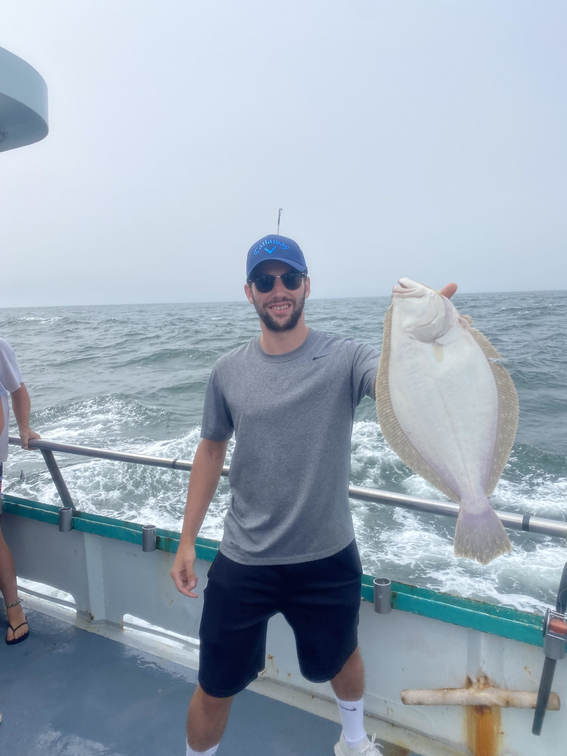 a man holding a fish on a boat in the water
