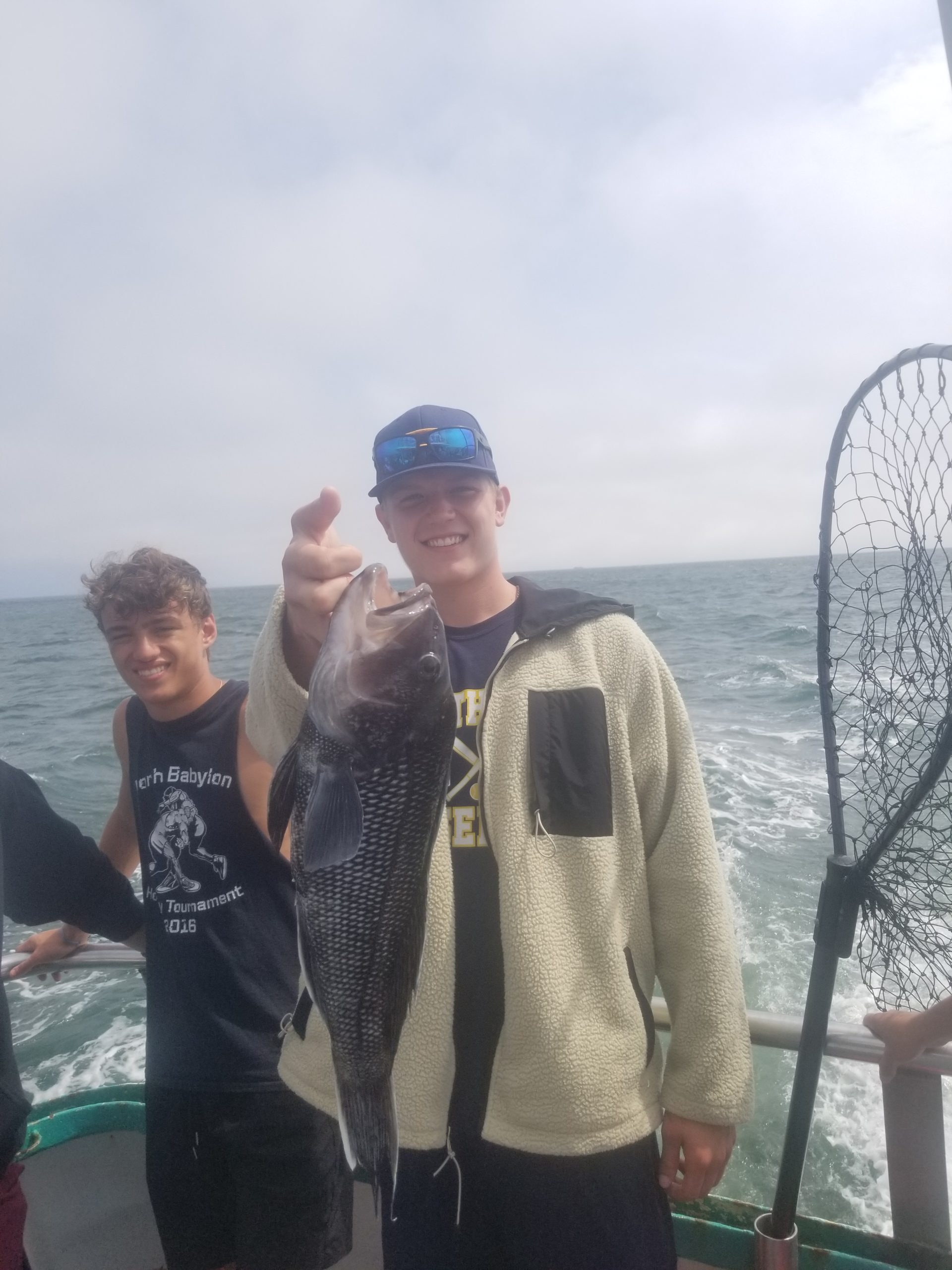 a couple of people standing next to a body of water