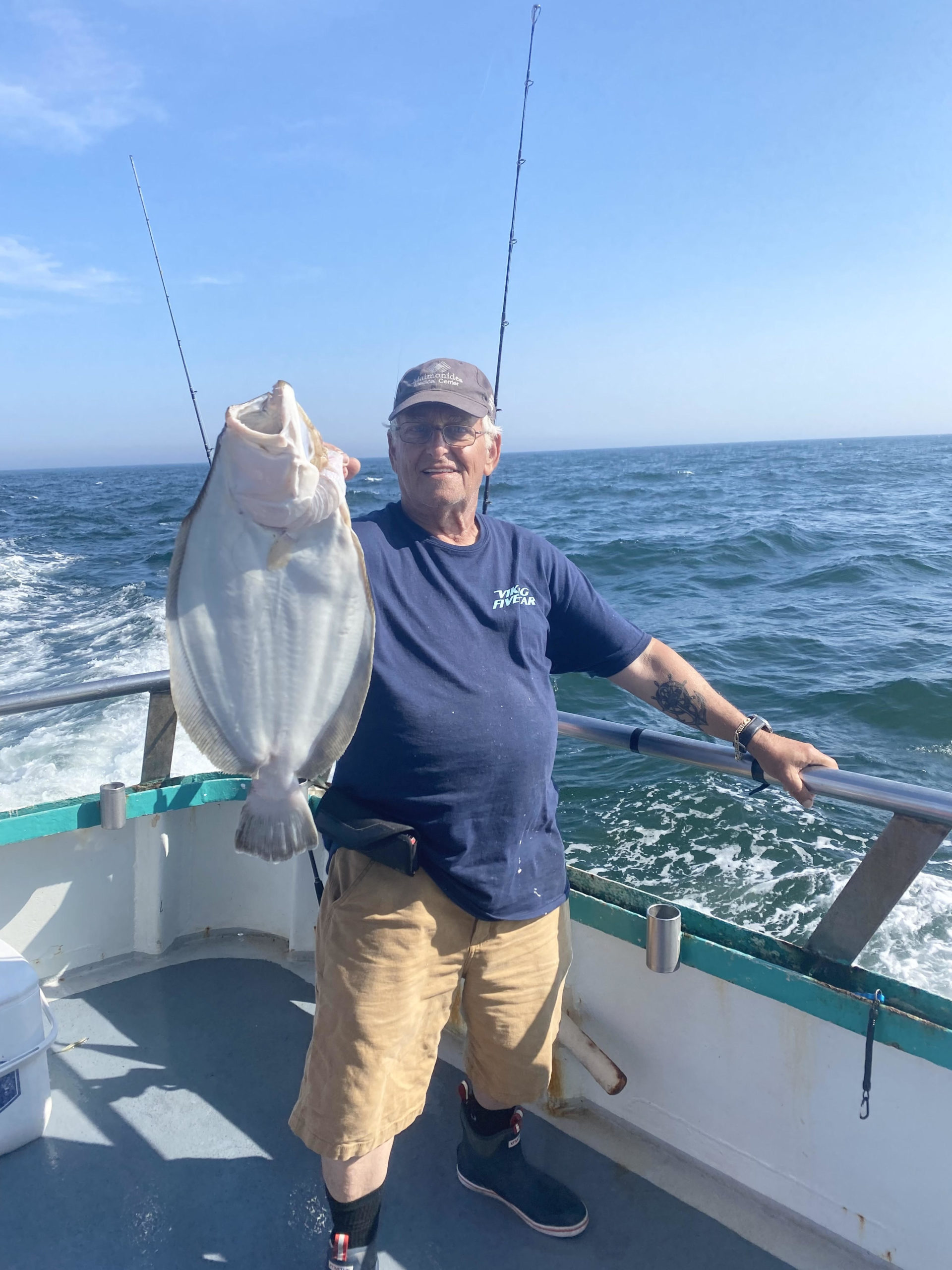 a man holding a fish on a boat in the water