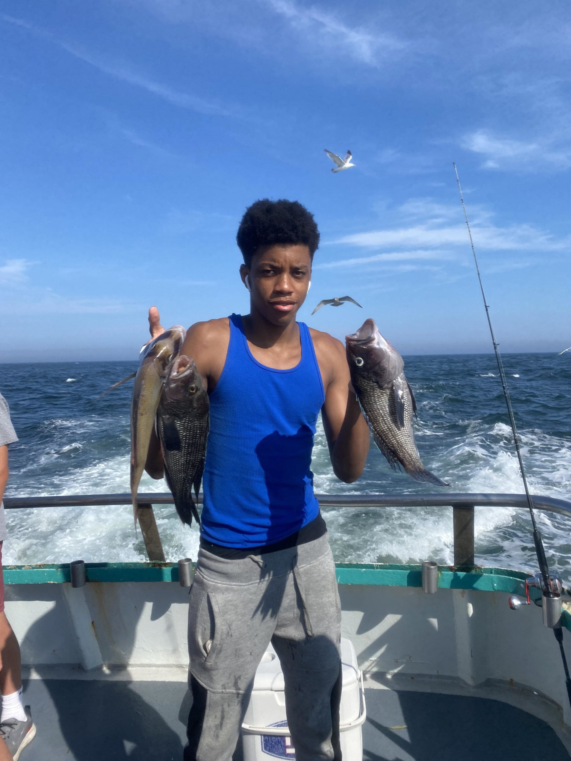 a man holding a fish on a boat in a body of water