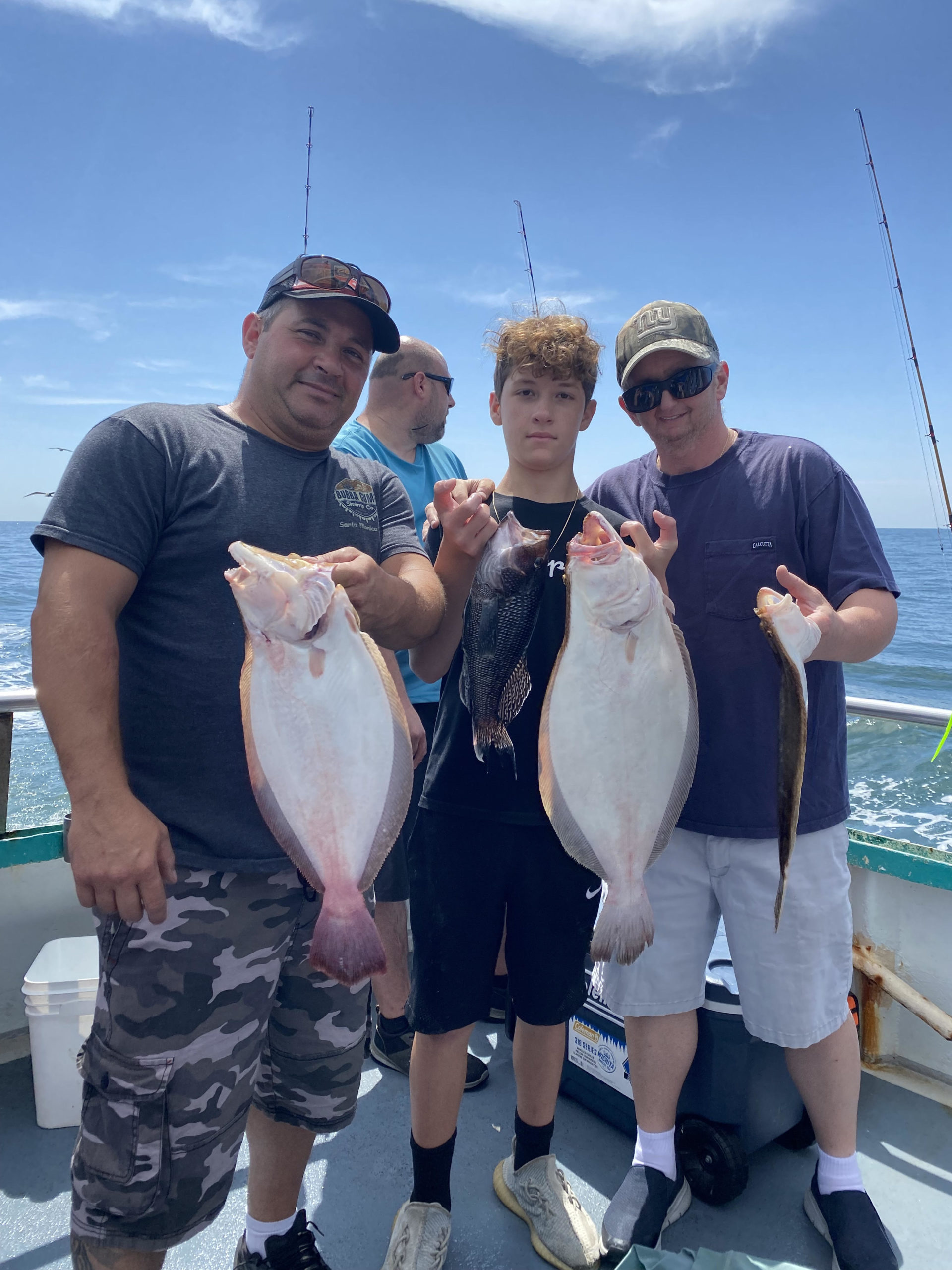 a group of people standing next to a man holding a fish
