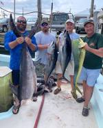 a group of people standing next to a person holding a fish